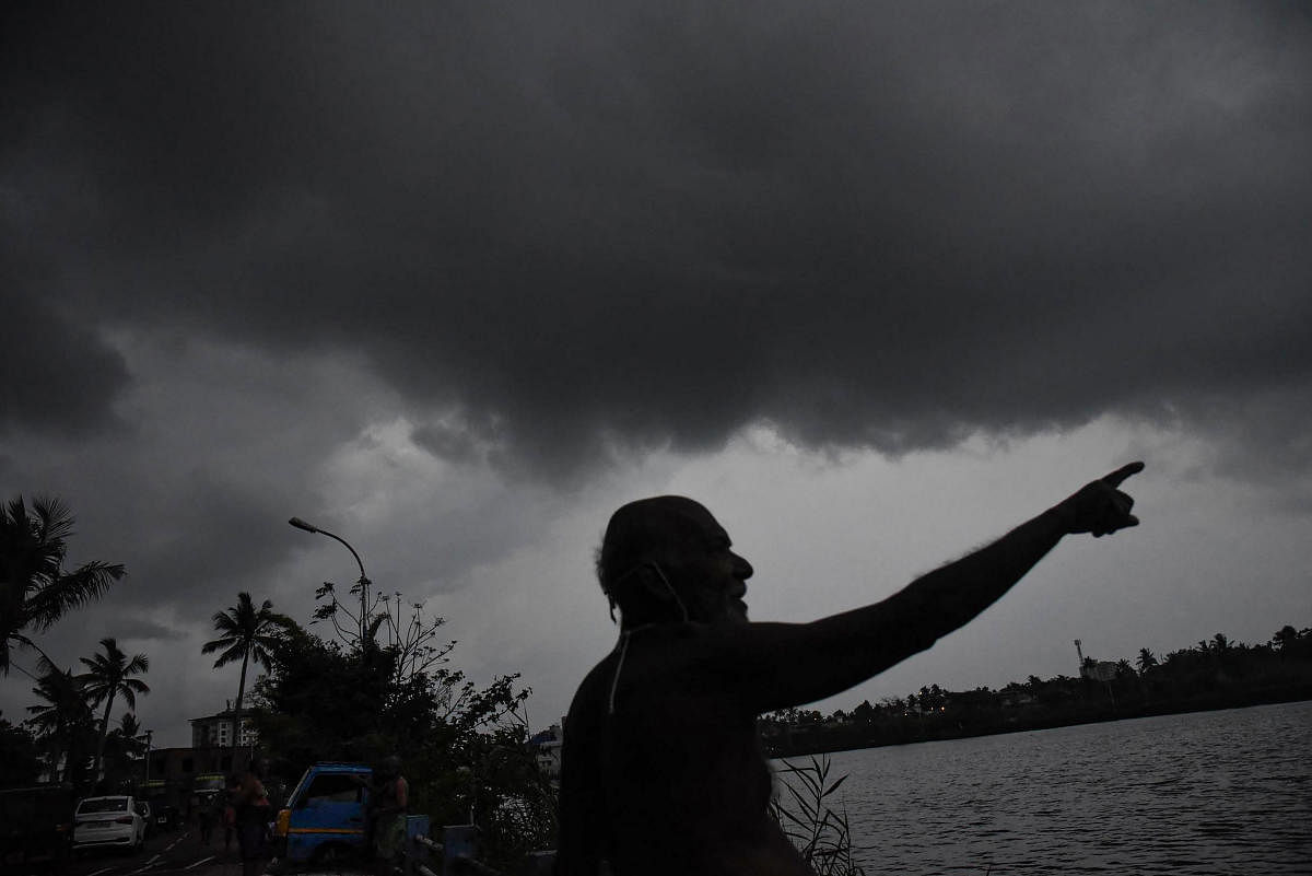 A man is silhoutted as dark clouds hover over the sky in the background, during the ongoing COVID-19 nationwide lockdown, in Kochi. AFP