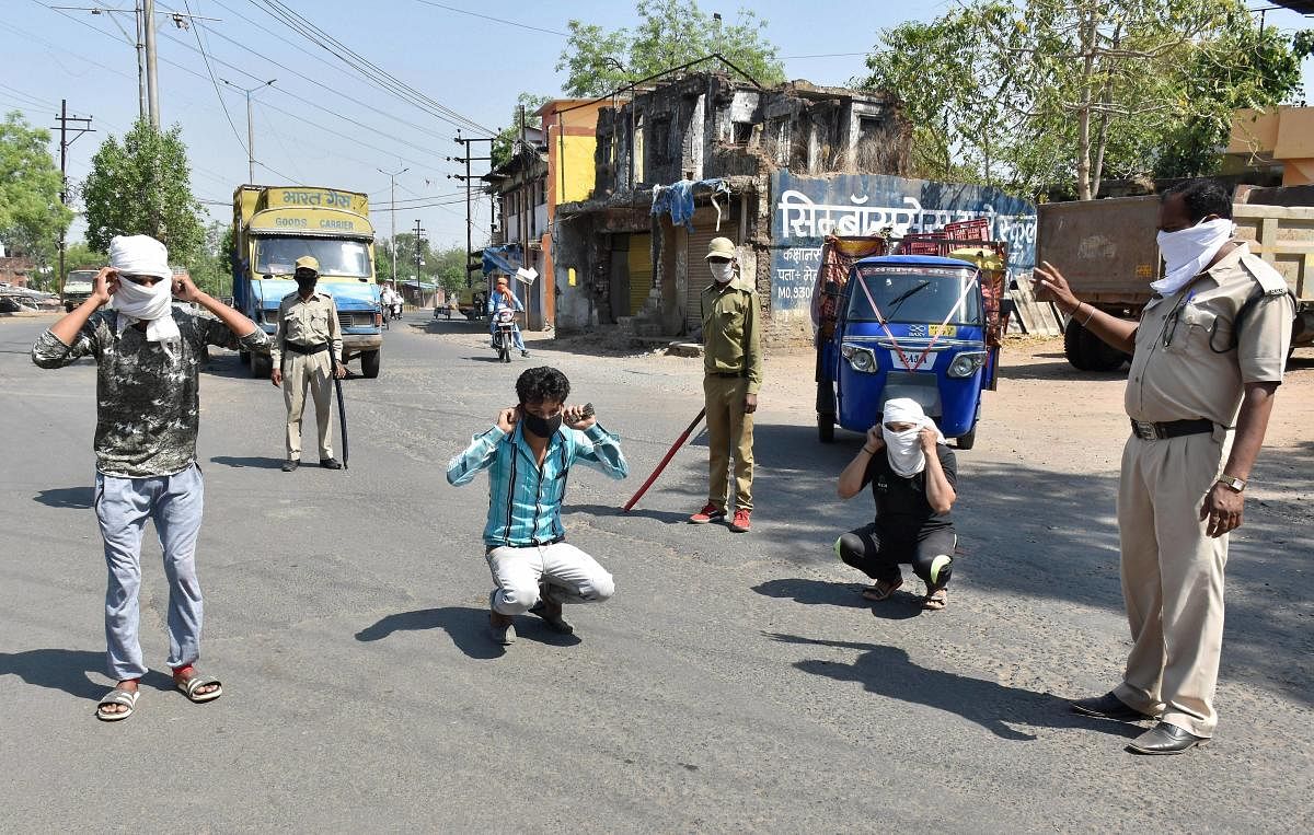 Policemen punish commuters for flouting curfew norms (PTI Photo)