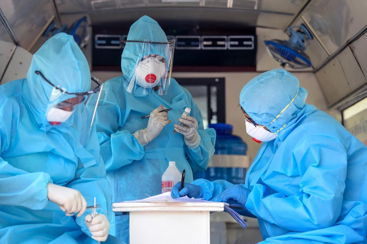 Health workers work on samples of swab test (PTI Photo)