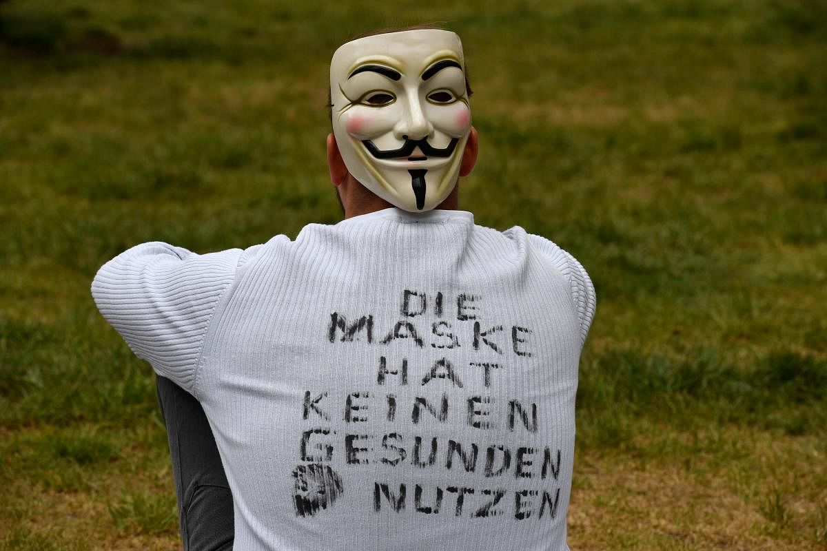  In this file photo taken on May 2, 2020 a demonstrator wearing a mask and a T-shirt with inscriptions reading 'The mask has no healthy use' sits in the demo area during a protest against the Corona restrictions in Berlin, amid the new coronavirus COVID-19 pandemic. Credit: AFP File Photo
