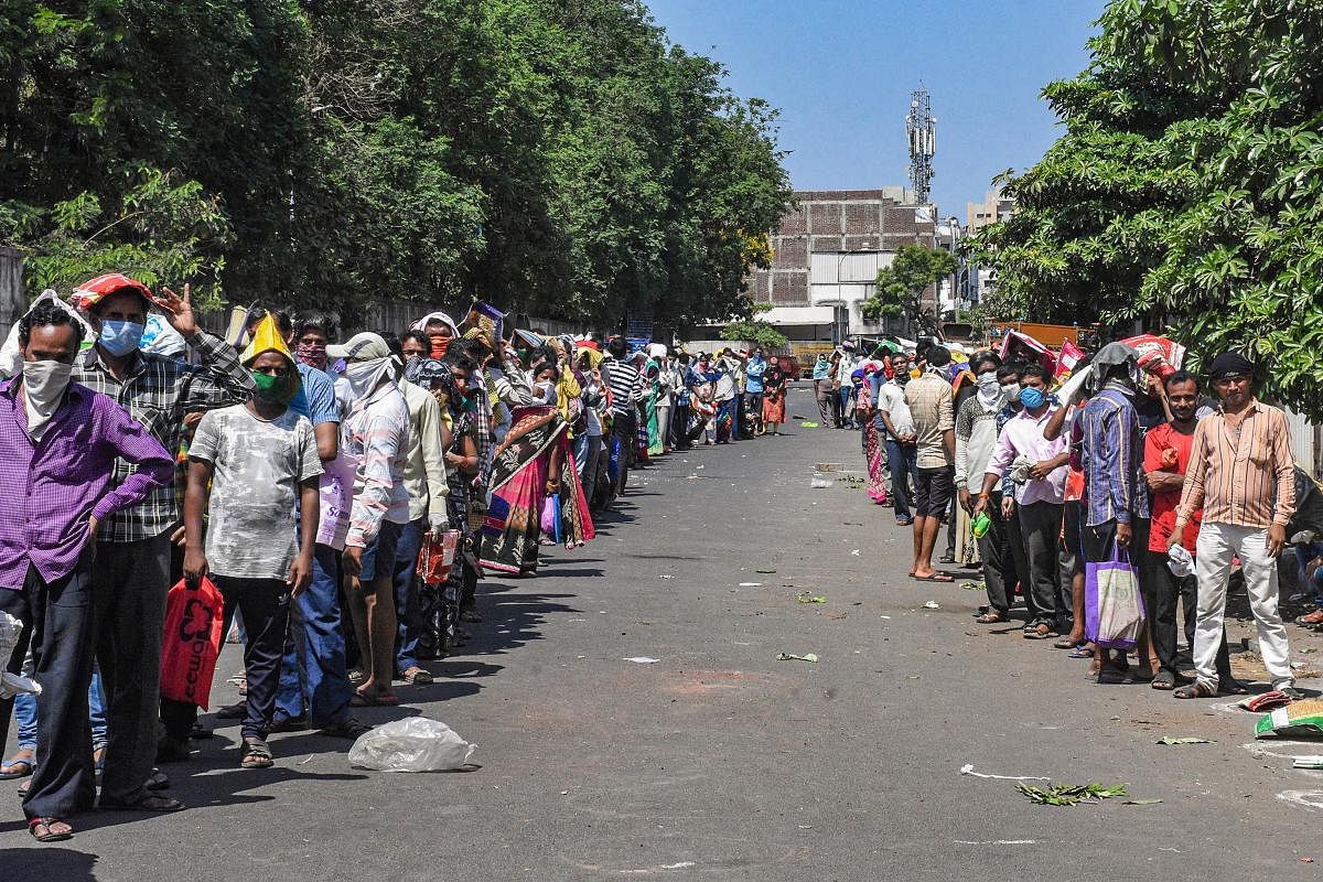  People stand in a queue without maintaining social distance to collect free ration (PTI Photo)