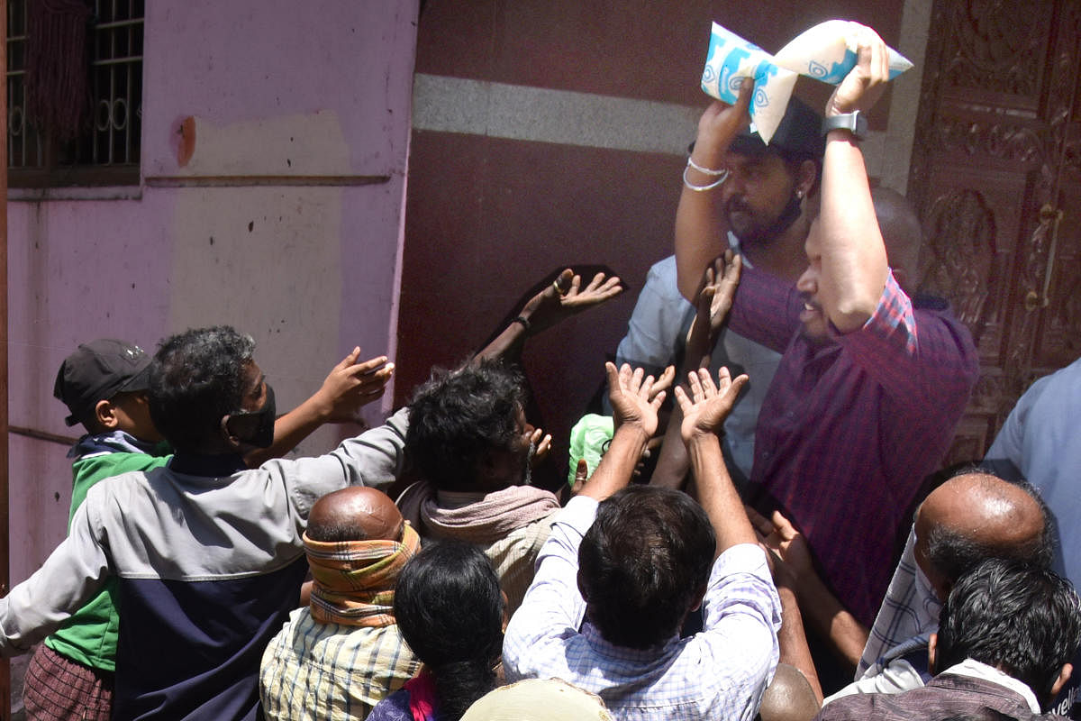 BBMP officials distributing free milk to people due to caronavirus lockdown at Kalasipalya. Photo by S K Dinesh