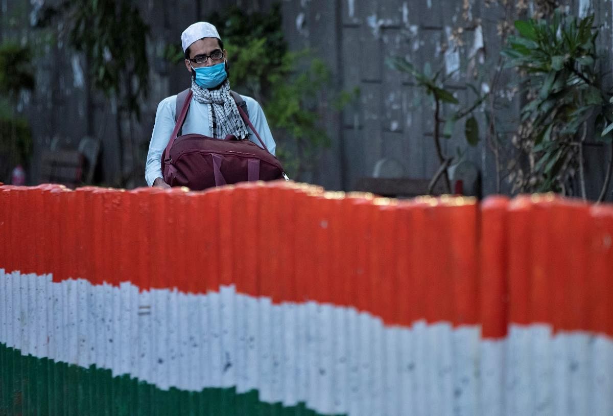 A man wearing a protective mask walks to board a bus that will take him to a quarantine facility, amid concerns about the spread of coronavirus disease (COVID-19), in Nizamuddin area of New Delhi. Credit: Reuters File Photo