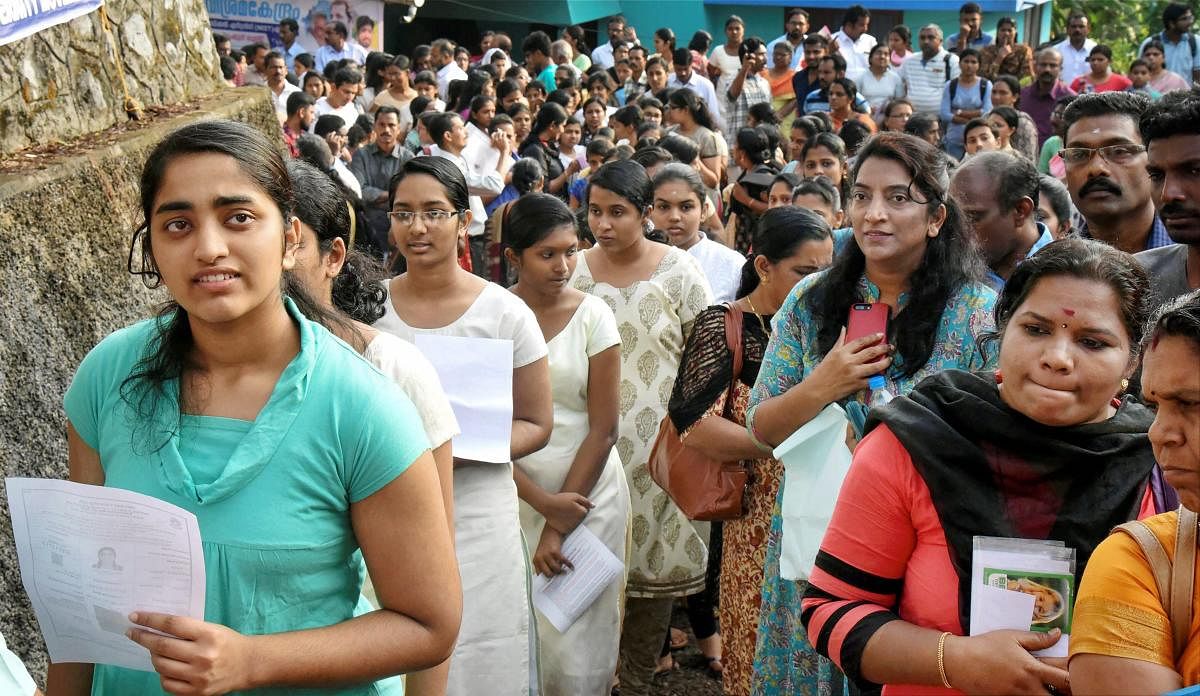 Applicants wait outside an examination centre to appear in the NEET 2018 test conducted by CBSE in Kochi on Sunday. PTI/FILE