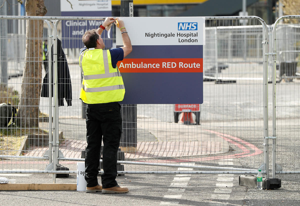 Staff put up some signs at the NHS Nightingale Hospital as the spread of the coronavirus disease (COVID-19) continues, London, Britain, April 3, 2020. REUTERS/John Sibley