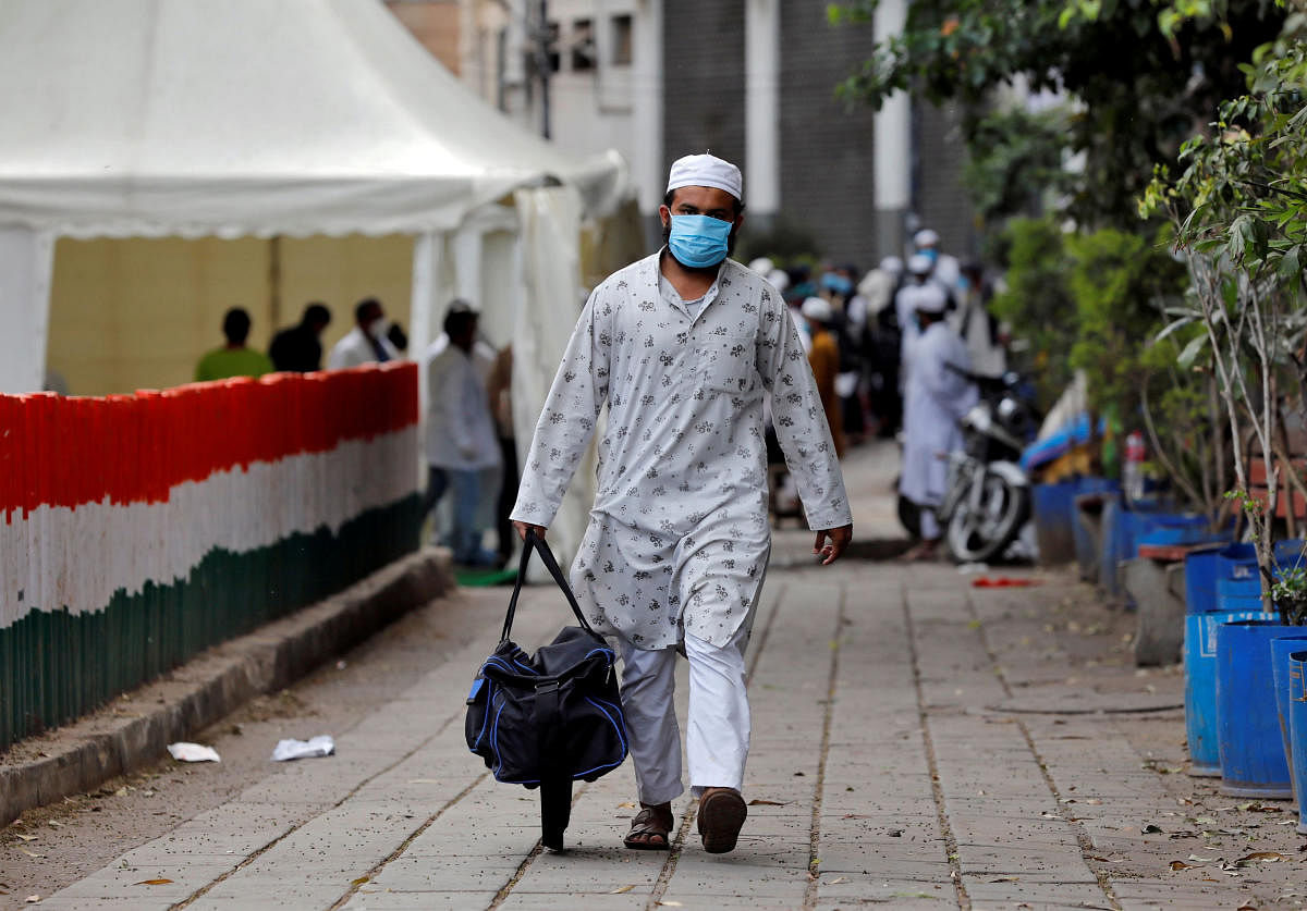 A man wearing a protective mask walks to board a bus that will take him to a quarantine facility, amid concerns about the spread of coronavirus disease (COVID-19), in Nizamuddin area of New Delhi, India, March 30, 2020. Credit: Reuters File Photo