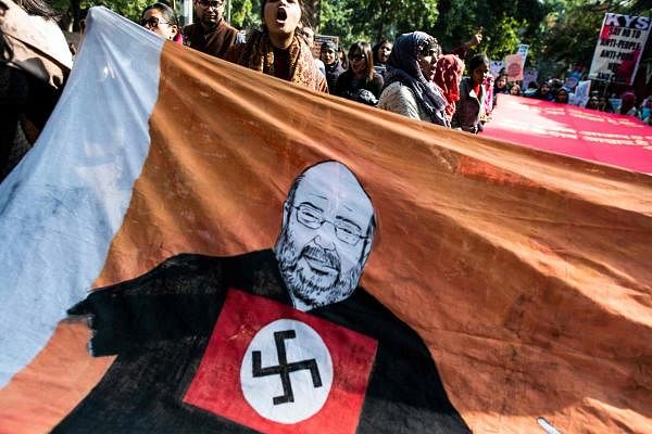 Protesters shout slogans next to a large caricature of Indian Home Minister Amit Shah with a Nazi Party swastika symbol during a demonstration against a new citizenship law in New Delhi on January 3, 2020. (AFP Photo)