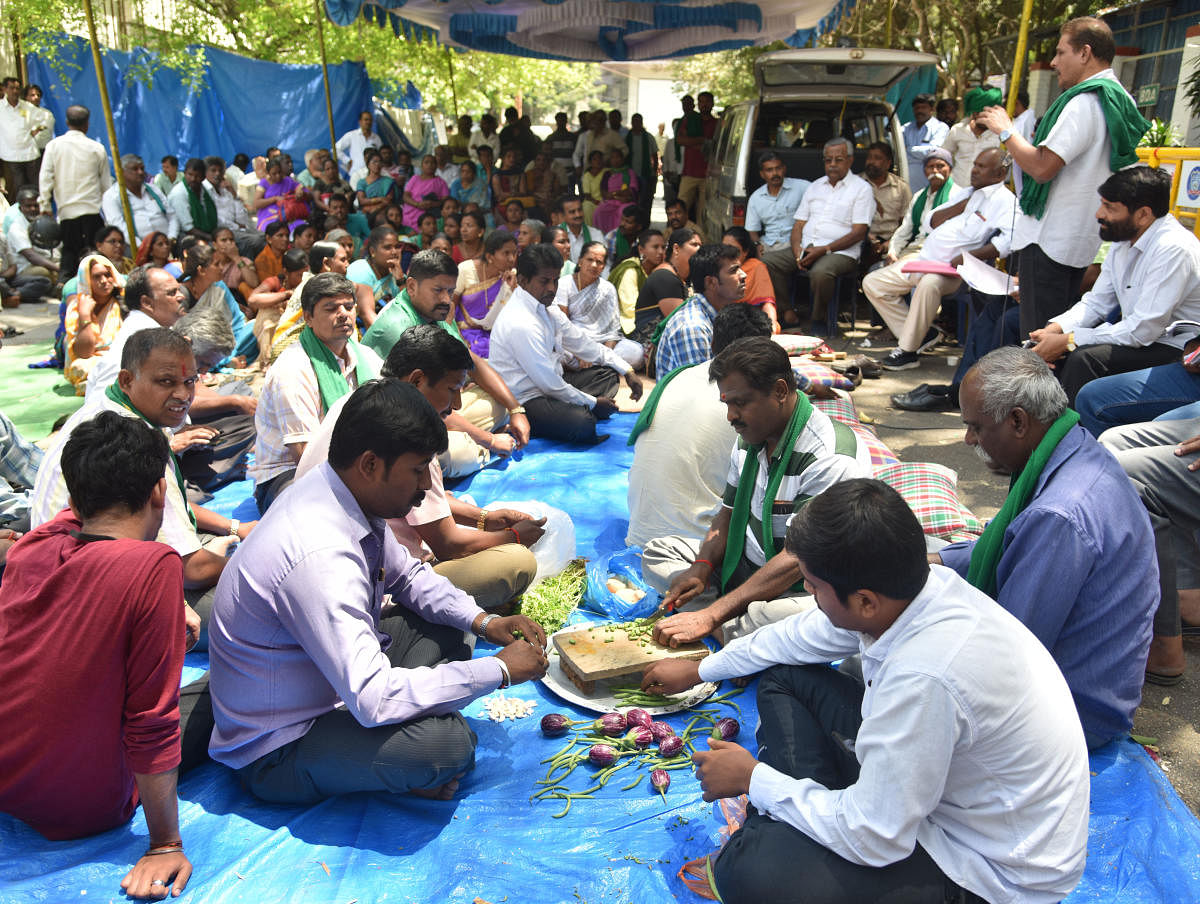 Farmers chop the vegetables for preparing lunch during the protest continues in front of BDA head office against the delay in the Peripheral Ring Road (PRR) project on in Bengaluru on Wednesday March 13th 2019.  (Credit: DH)