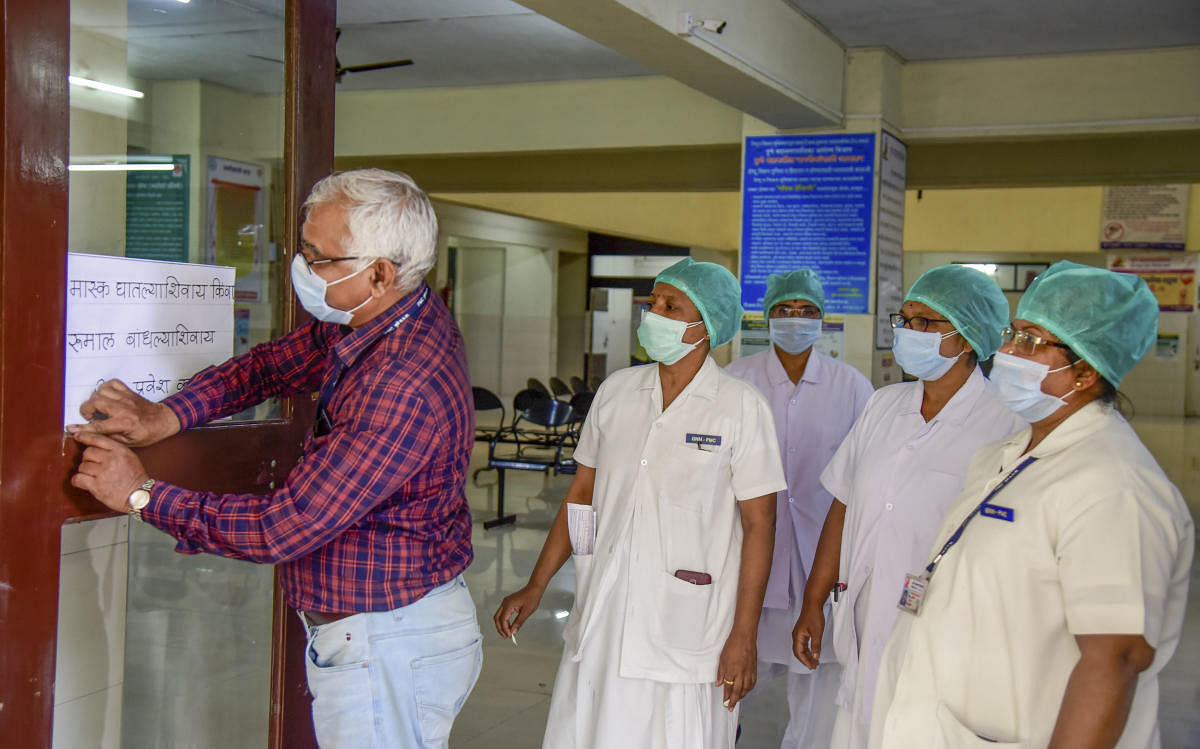 Medical staff pastes a notice on prevention against coronavirus, at the isolation ward of Naidu Hospital, in Pune, Wednesday, March 4, 2020. (PTI Photo)