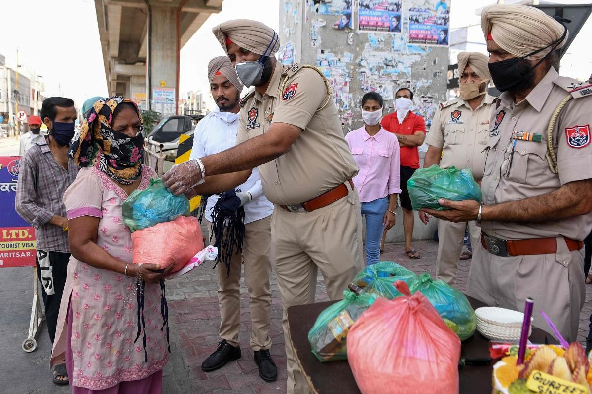 Punjab Police personnel distribute grocery items to people in need in Amritsar (AFP Photo)