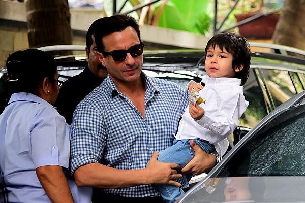 Bollywood actors Saif Ali Khan (C) with his son Taimur Ali Khan arrives for a Christmas brunch in Mumbai on December 25, 2019. (AFP Photo)