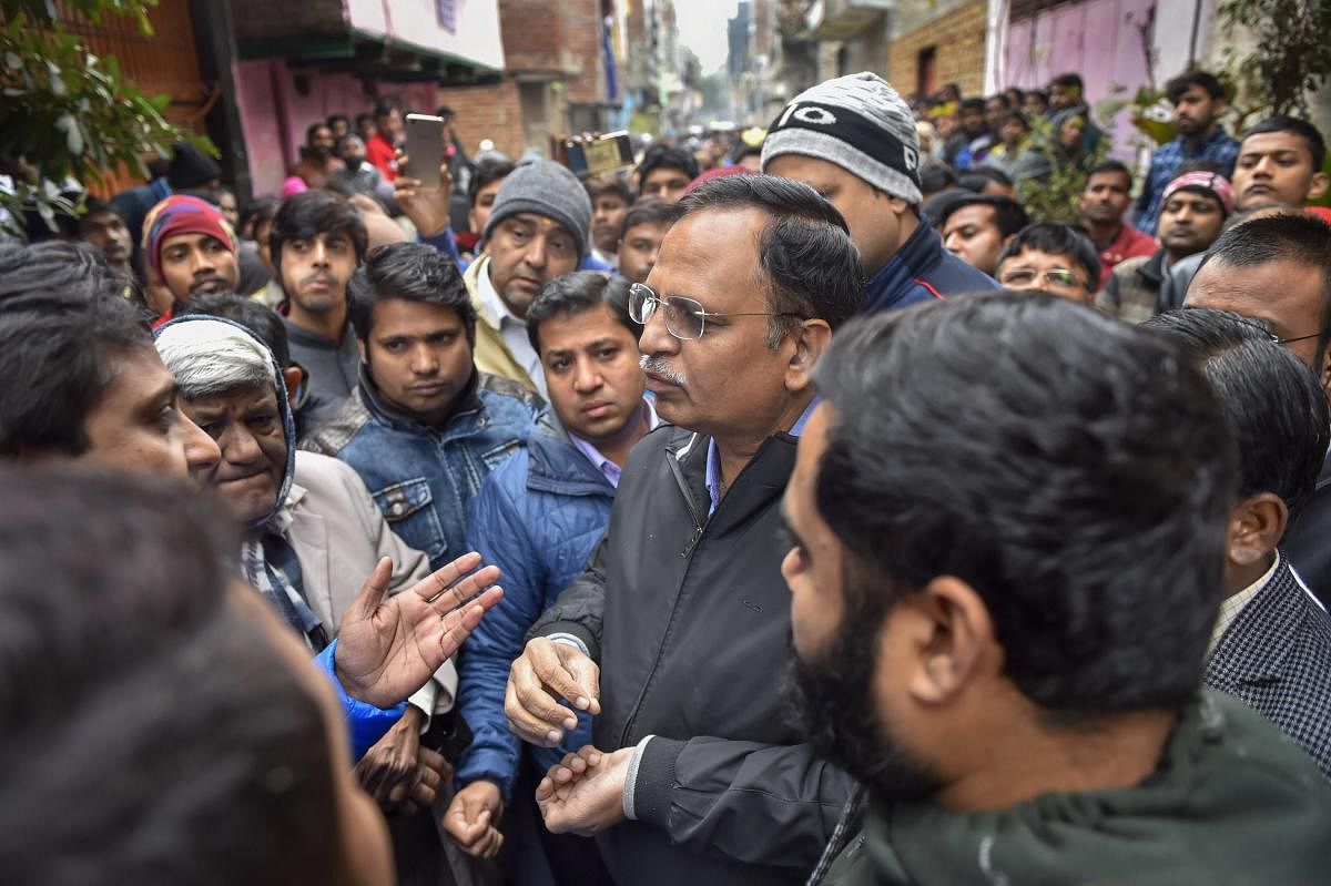  Delhi Health Minister Satyendar Jain interacts with the residents, where a fire broke out in a three-storey residential-cum-commercial building, in outer Delhi's Kirari area, Monday, Dec. 23, 2019. At least nine people, including three children, were killed in the incident. (PTI Photo/Ravi Choudhary)