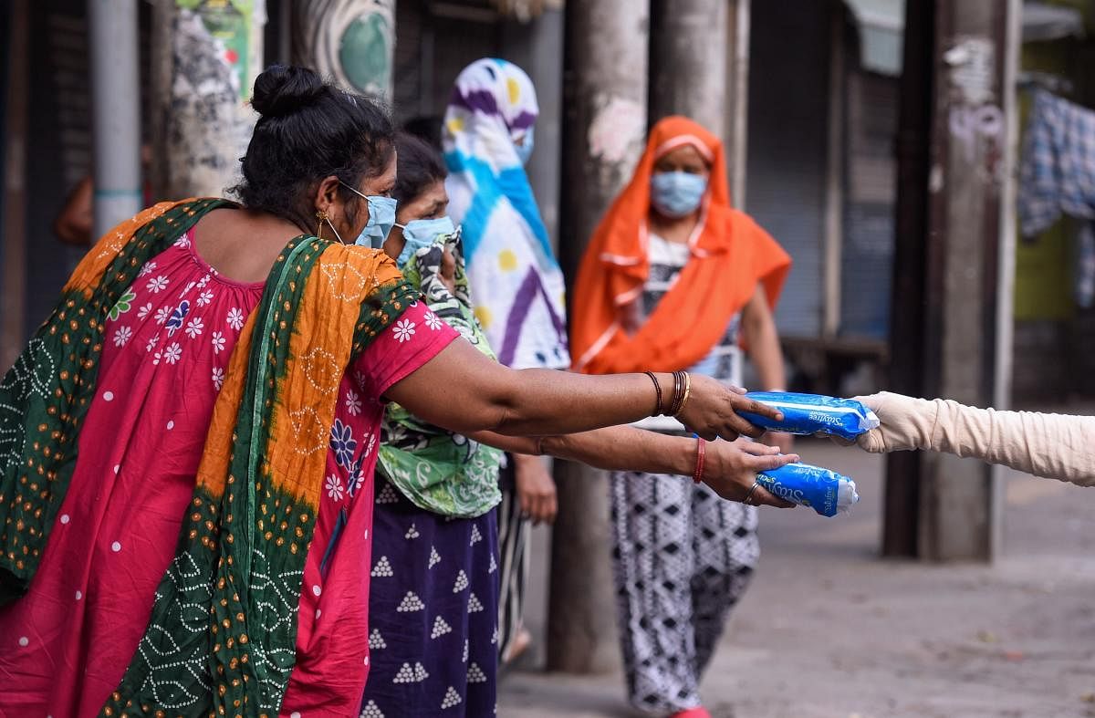  Sex workers collect sanitary napkins at GB Road during a nationwide lockdown imposed in the wake of coronavirus pandemic, in New Delhi, Saturday, April 18, 2020. (PTI Photo)