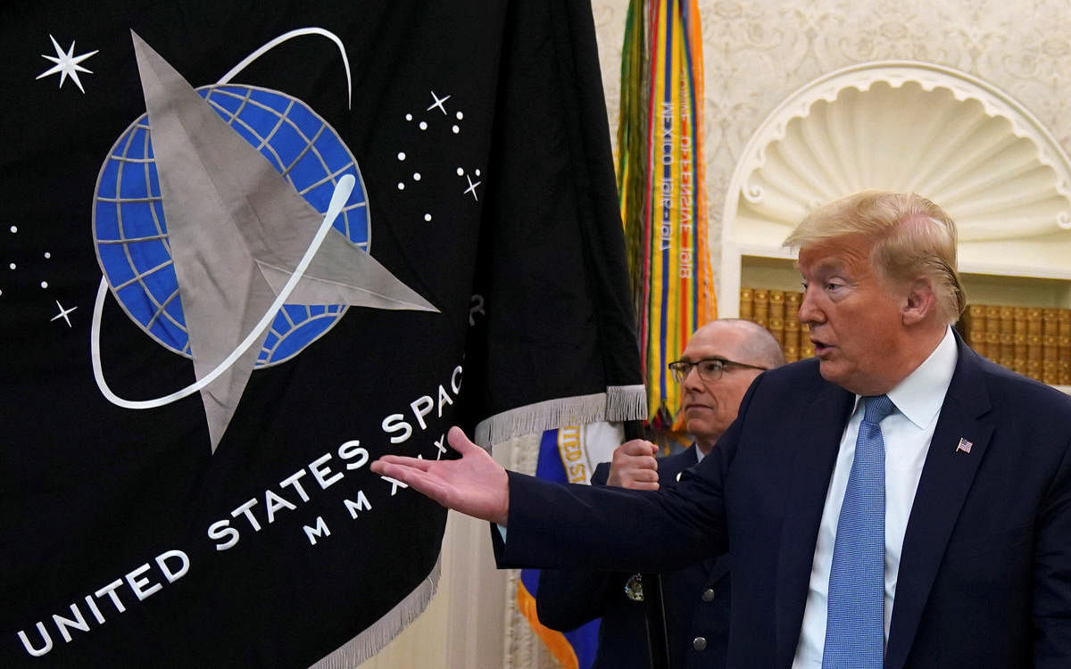 U.S. President Donald Trump gestures towards the U.S. Space Force flag during a presentation of the flag in the Oval Office of the White House in Washington, U.S., May 15, 2020. Credit: Reuters Photo