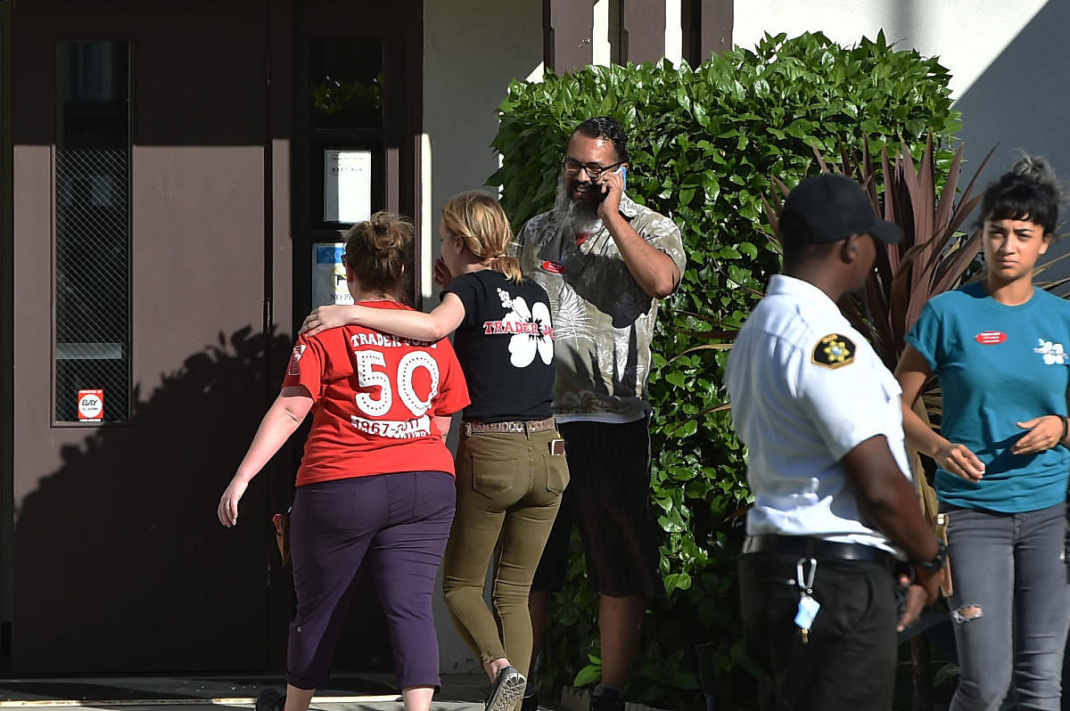 A TraderJoe's employee is comforted after a suspect barricaded inside the supermarket in Silverlake, Los Angeles. AFP.