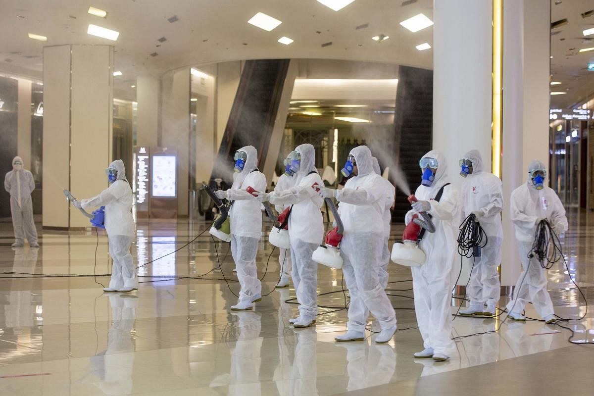 Cleaners in hazmat suits demonstrate disinfection at Siam Paragon, an upmarket shopping mall in Bangkok, Thailand (AP Photo)