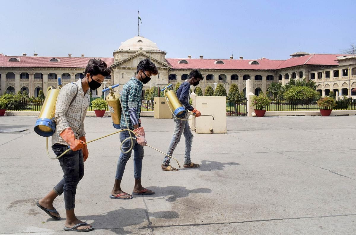 Workers fumigate the premises of the Allahabad High Court, closed as a precautionary measure against the spread of coronavirus. PTI