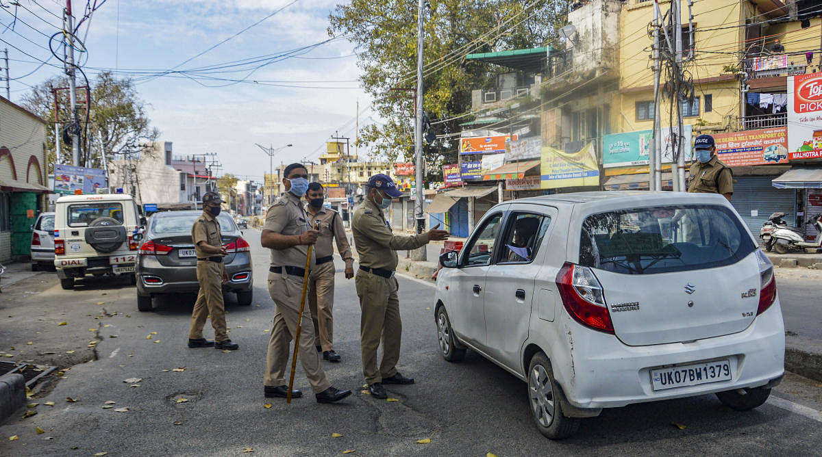 Police personnel stop commuters after the state government enforced lockdown in the city amid coronavirus pandemic, in Dehradun, Tuesday, March 24, 2020. (PTI Photo)