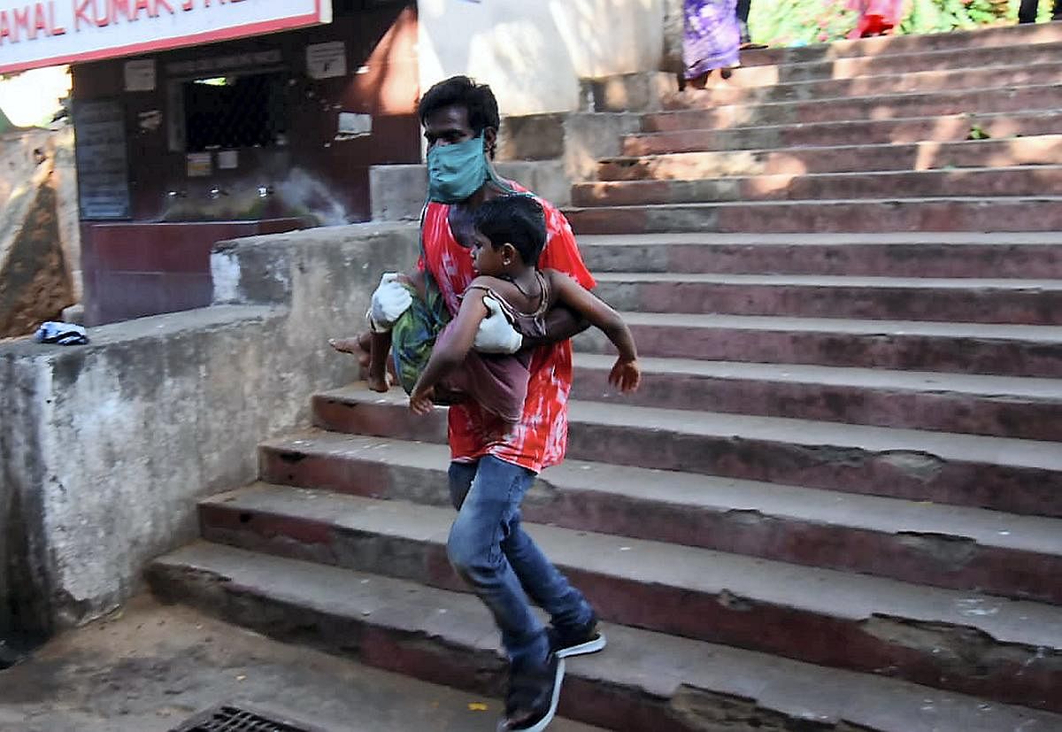 A father rushes to take his child for treatment at King George Hospital after a major chemical gas leakage at LG Polymers industry in RR Venkatapuram village, Visakhapatnam, Thursday, May 07, 2020. (PTI Photo)