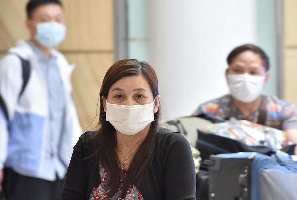 Passangers arrive at Sydney airport wearing masks after landing on January 25, 2020. (AFP Photo)