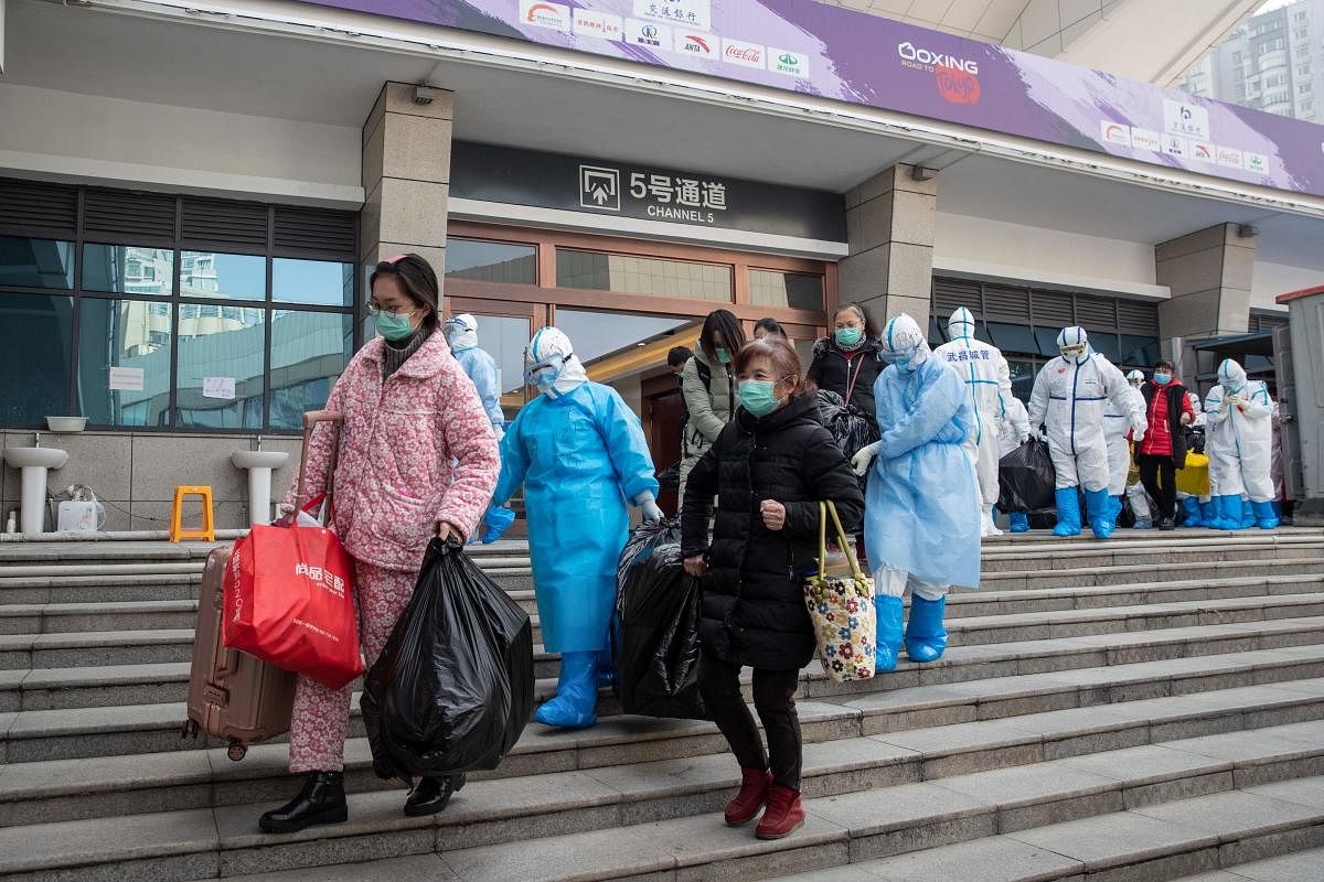 This photo taken on March 10, 2020 shows people who have recovered from the COVID-19 coronavirus leaving a temporary hospital set up to treat people with the COVID-19 coronavirus in Wuhan in China's central Hubei province. Credit: AFP Photo