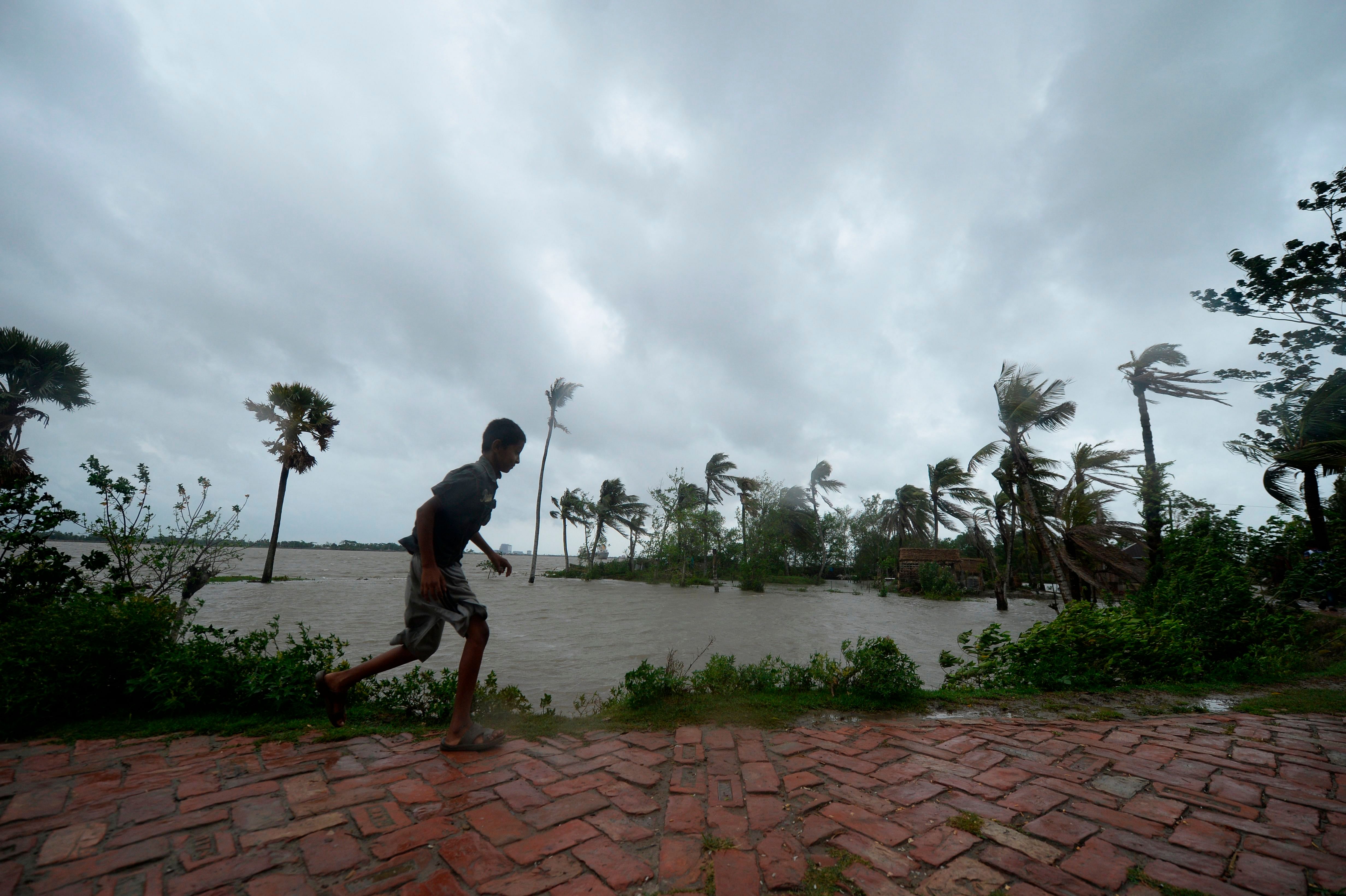 A boy runs along an embankment ahead of the expected landfall of cyclone Amphan. (AFP Photo)