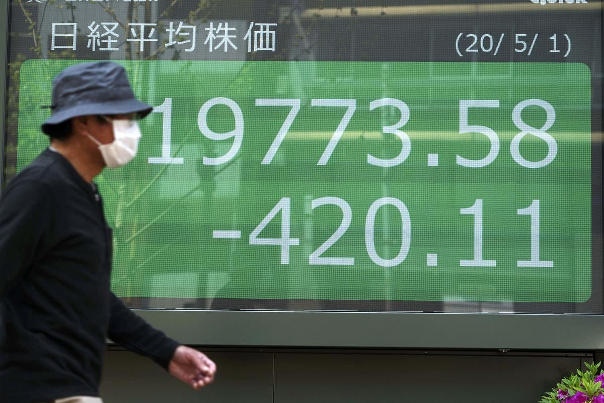  A man walks past an electronic stock board showing Japan's Nikkei (AP Photo)