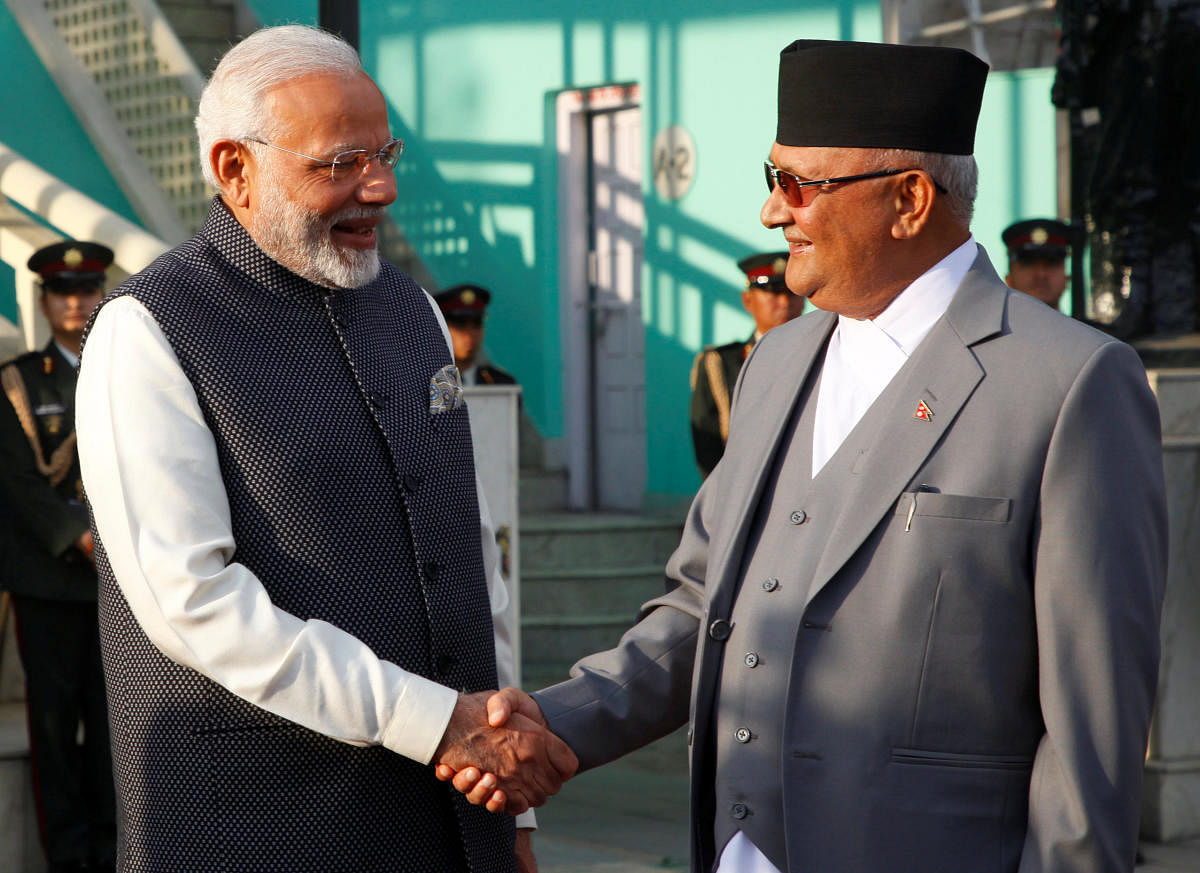India's Prime Minister Narendra Modi shakes hand with his Nepalese counterpart Khadga Prasad Sharma Oli, also known as K.P. Oli, after inspecting a guard of honour upon his arrival in Kathmandu, Nepal May 11, 2018. REUTERS/Hemanta Shrestha