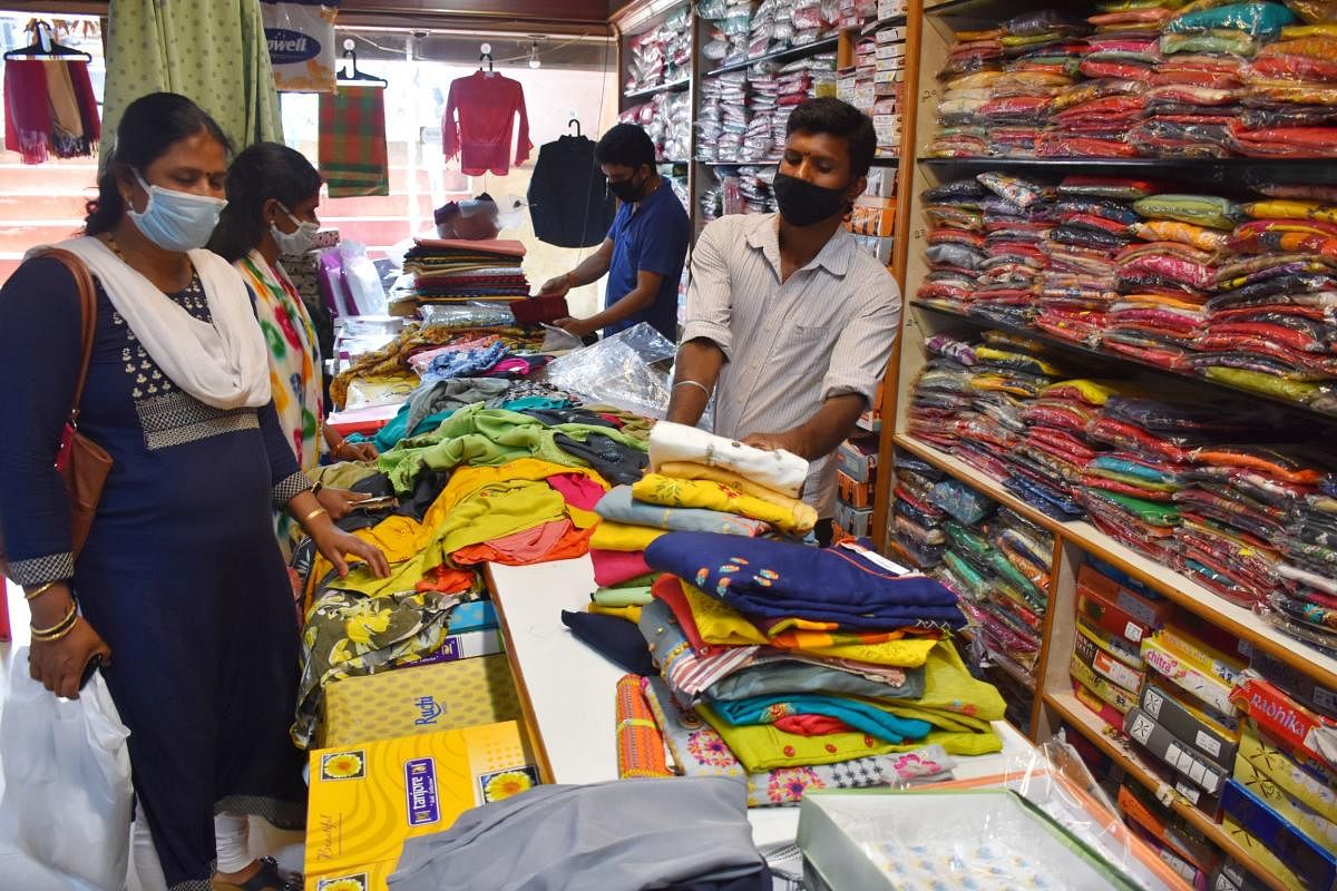 Customers buy clothes at a shop in Madikeri. DH Photo