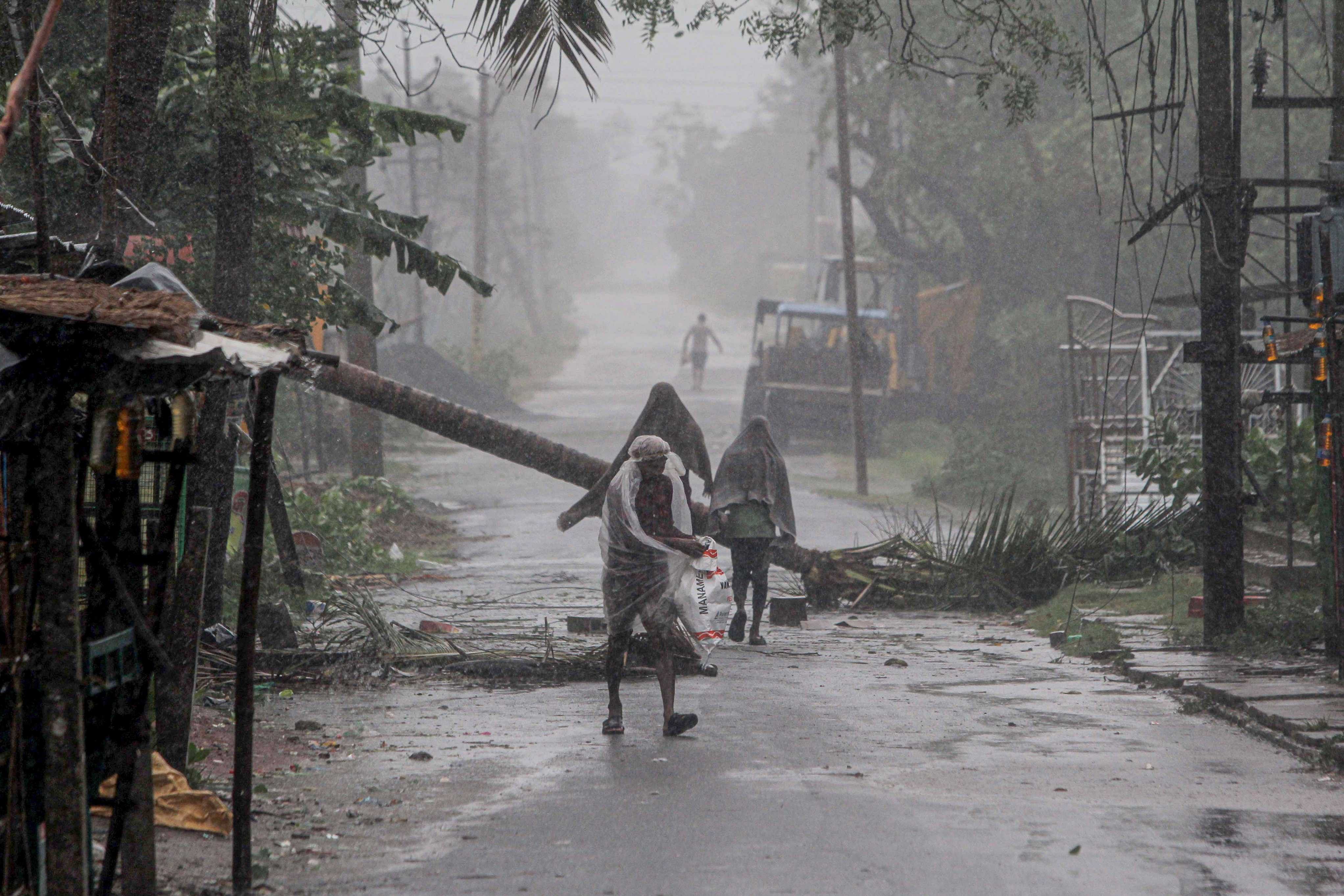 People make way through gusty winds as super cyclone Amphan makes landfall, near Dhamara Port in Bhadrak district. (PTI)