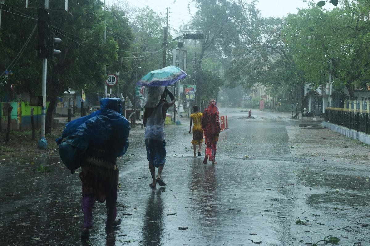 Residents walk along a street to a shelter ahead of the expected landfall of cyclone Amphan (AFP Photo)