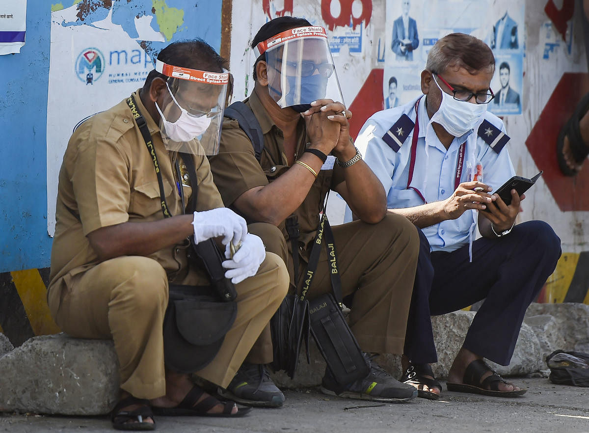 Security personnel sit outside the Dharavi slum, during ongoing COVID-19 lockdown, in Mumbai. PTI