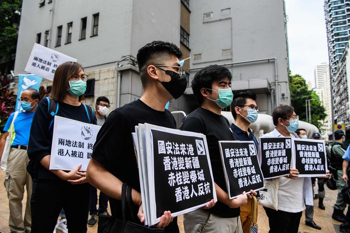 Pro-democracy protesters hold placards that translate as "National Security Law comes to Hong Kong (AFP Photo)