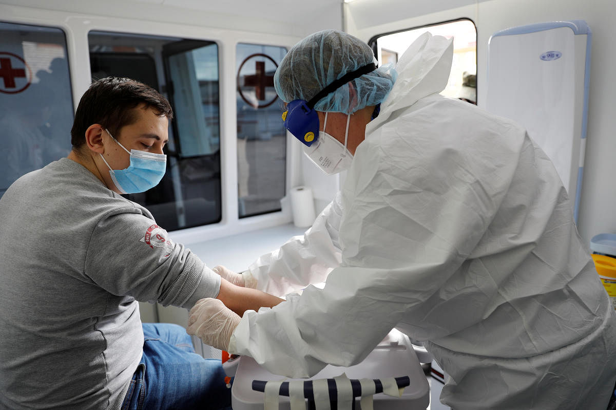 A medical specialist wearing personal protective equipment (PPE) takes a blood sample from a conscript to test for the coronavirus disease (COVID-19) at a recruiting station in Kaliningrad, Russia (Reuters Photo)