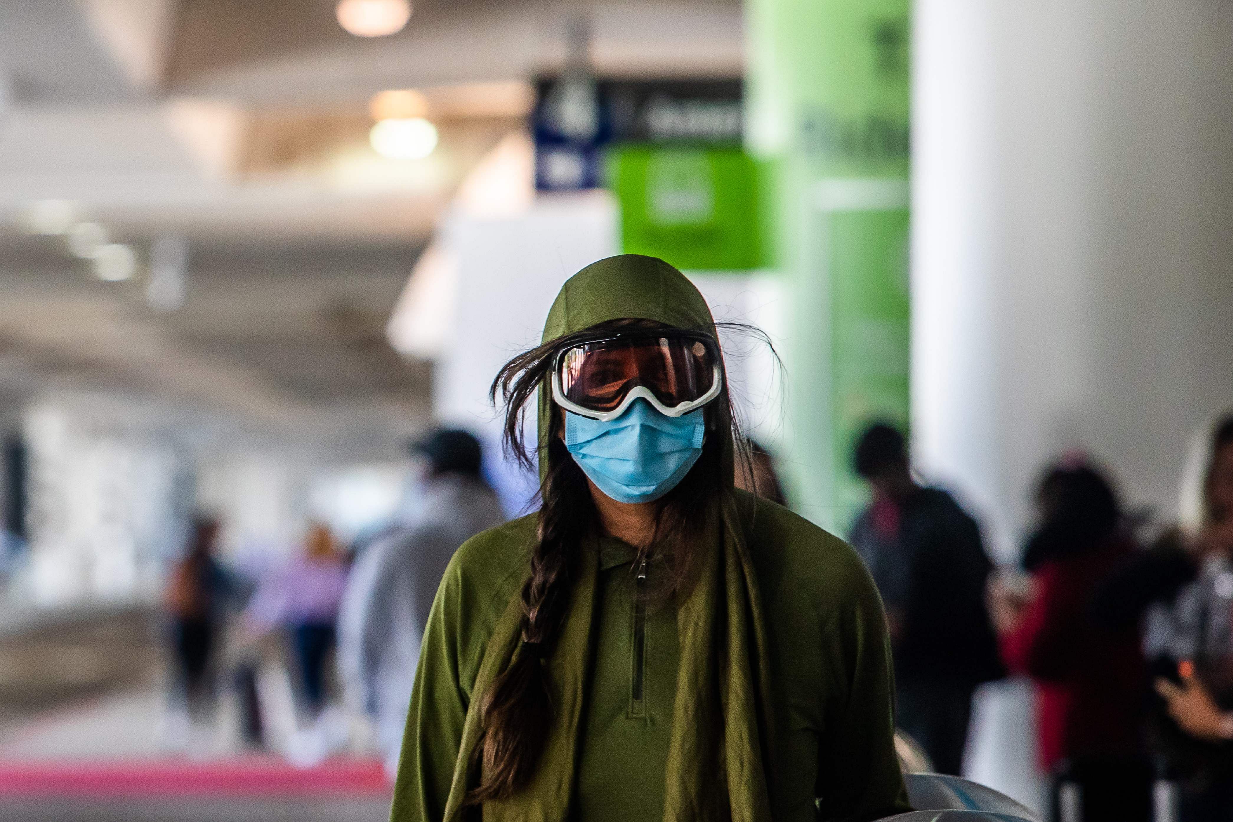 A woman wearing a face mask and goggles walks at LAX airport at the start of the Memorial Day holiday weekend during the novel coronavirus. (Credit: AFP photo)