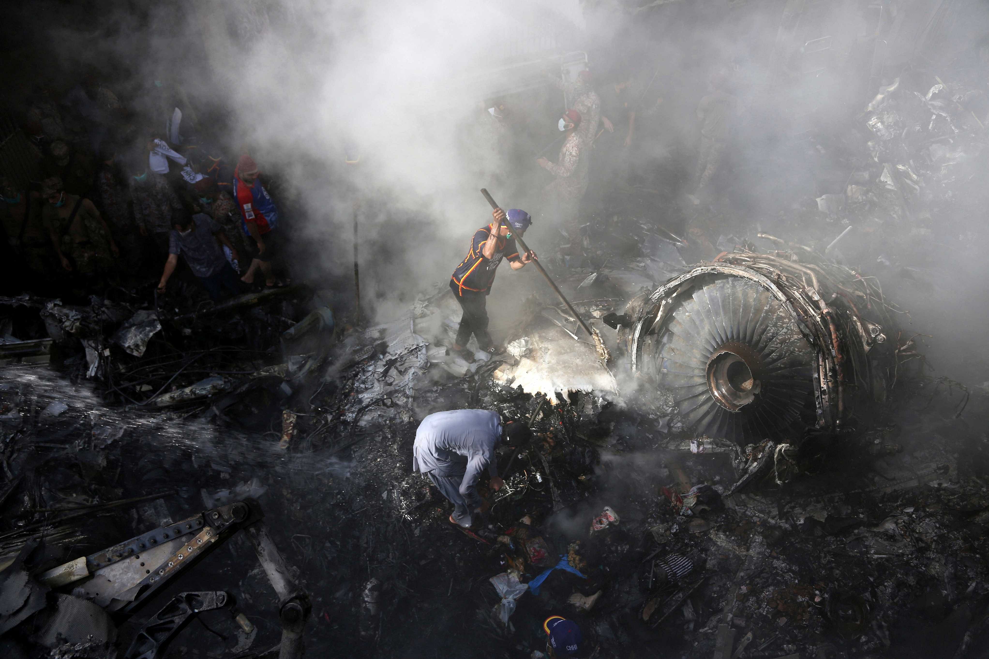 Volunteers look for survivors of a plane that crashed in a residential area of Karachi, Pakistan. (AP photo)