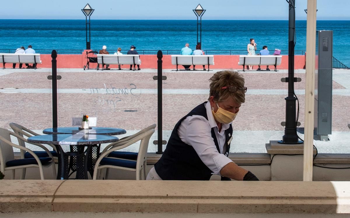 A waitress at the Travel Charme Hotel cleans a table at the seaside resort of Binz, on the island of Ruegen in north-eastern Germany. (AFP Photo)