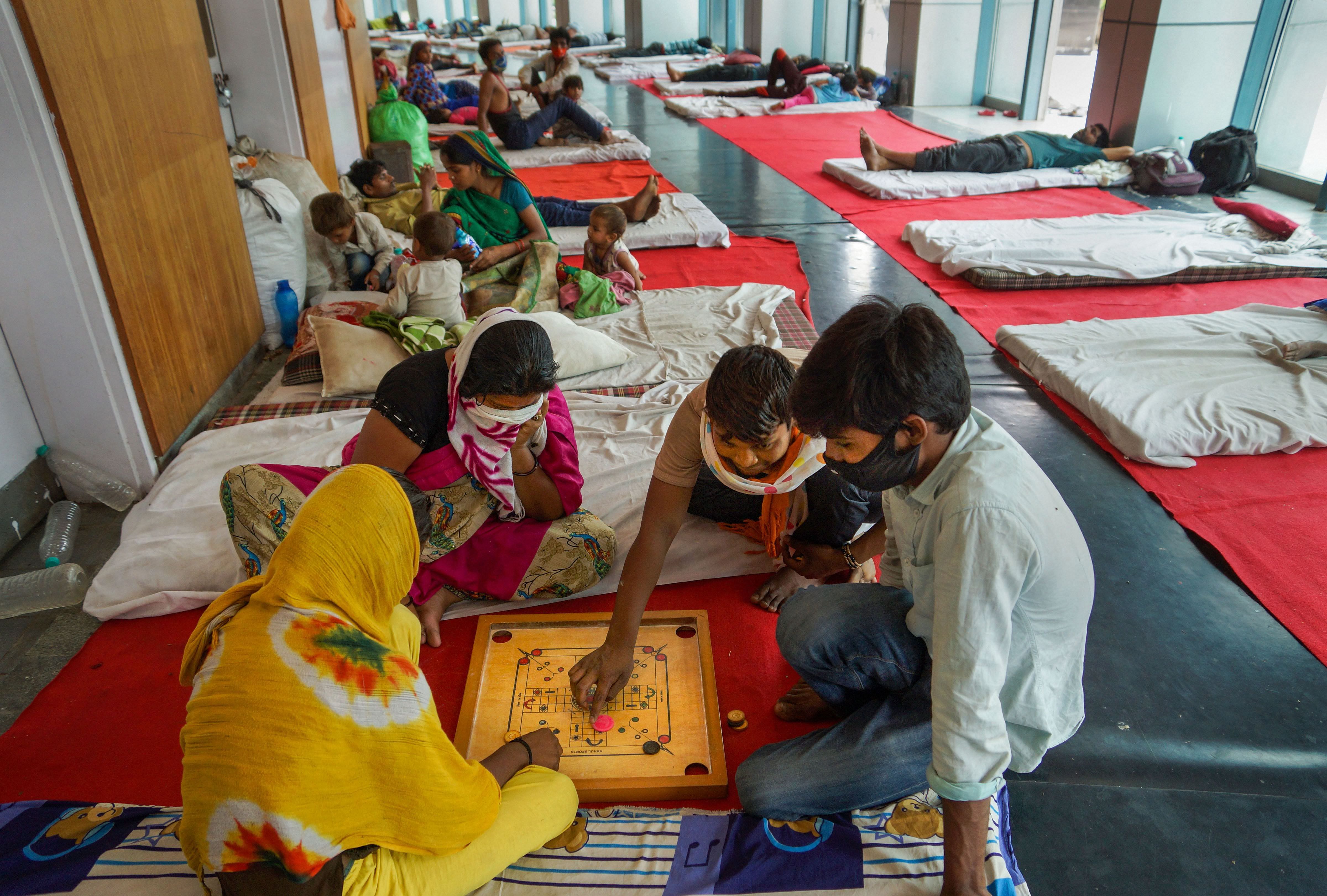 People staying at Yamuna Sports Complex, which is converted into a makeshift camp for those stranded in Delhi, play carom during the nationwide lockdown. (PTI file photo)