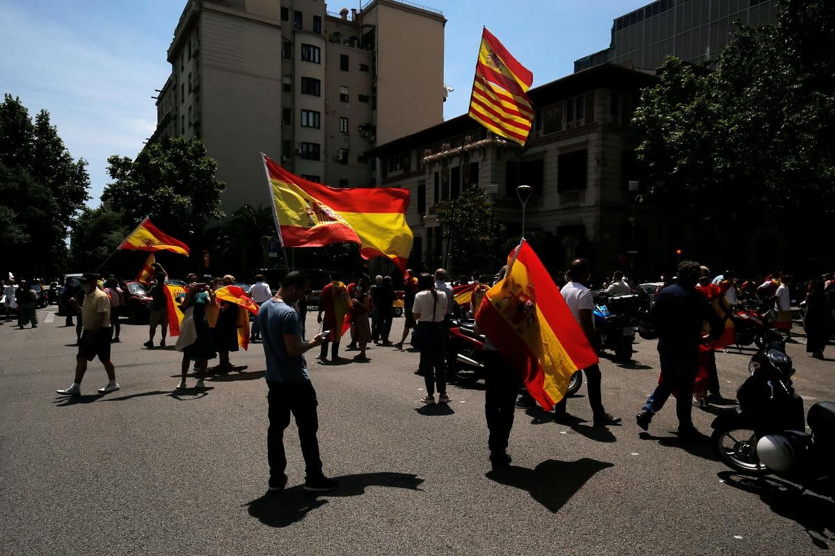 Demonstrators waving Spanish flags gather outside the central government's delegation headquarters during a "caravan for Spain and its freedom" protest by far-right party Vox in Barcelona on May 23, 2020. Credit: AFP Photo