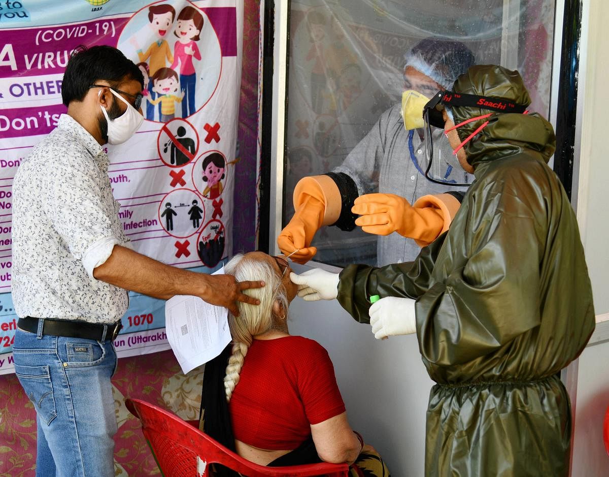  Medics take a swab sample of an elderly-woman for COVID-19 testing (PTI Photo)