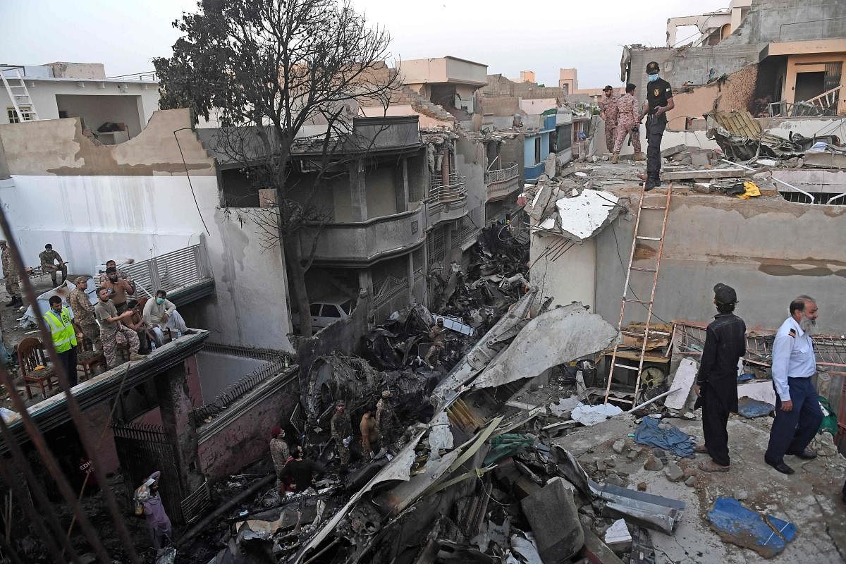 Security personnel search for victims in the wreckage of a Pakistan International Airlines aircraft after it crashed in a residential area in Karachi on May 22, 2020. Credit: AFP Photo