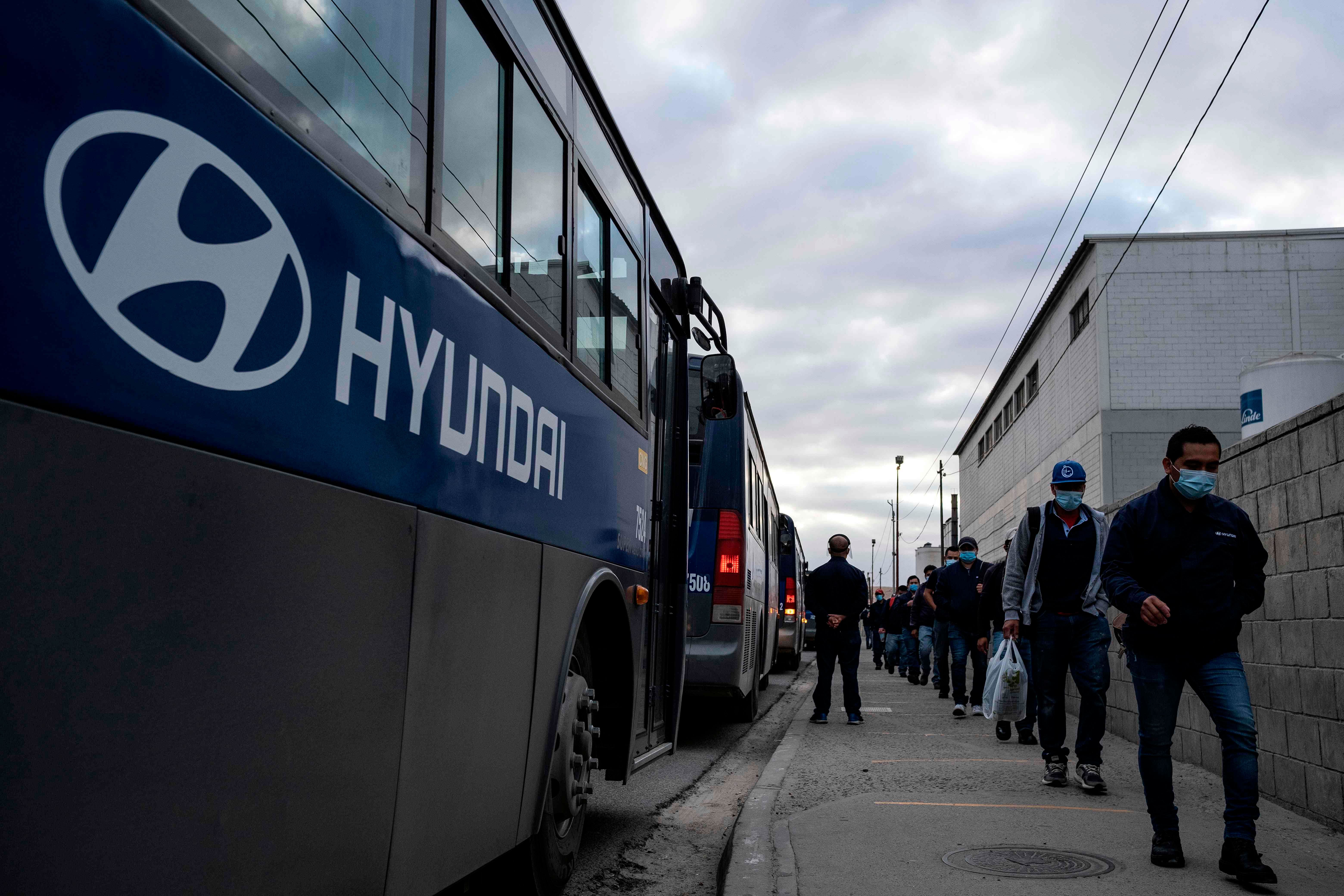 Production workers wearing face masks arrive for their shift at the Hyundai Plan. (AFP Photo)