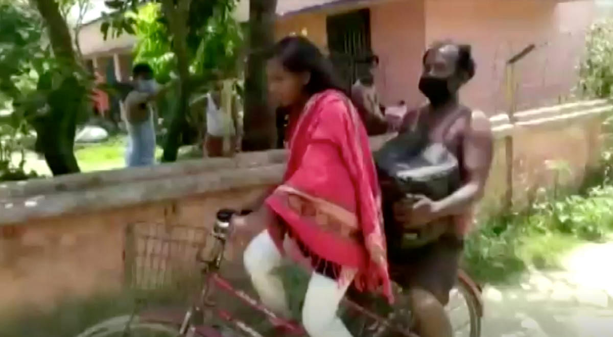 Jyoti Kumari carries her father on the back of her bicycle, in Darbhanga, Bihar, India May 21, 2020 in this still image taken from video. Credit: Reuters
