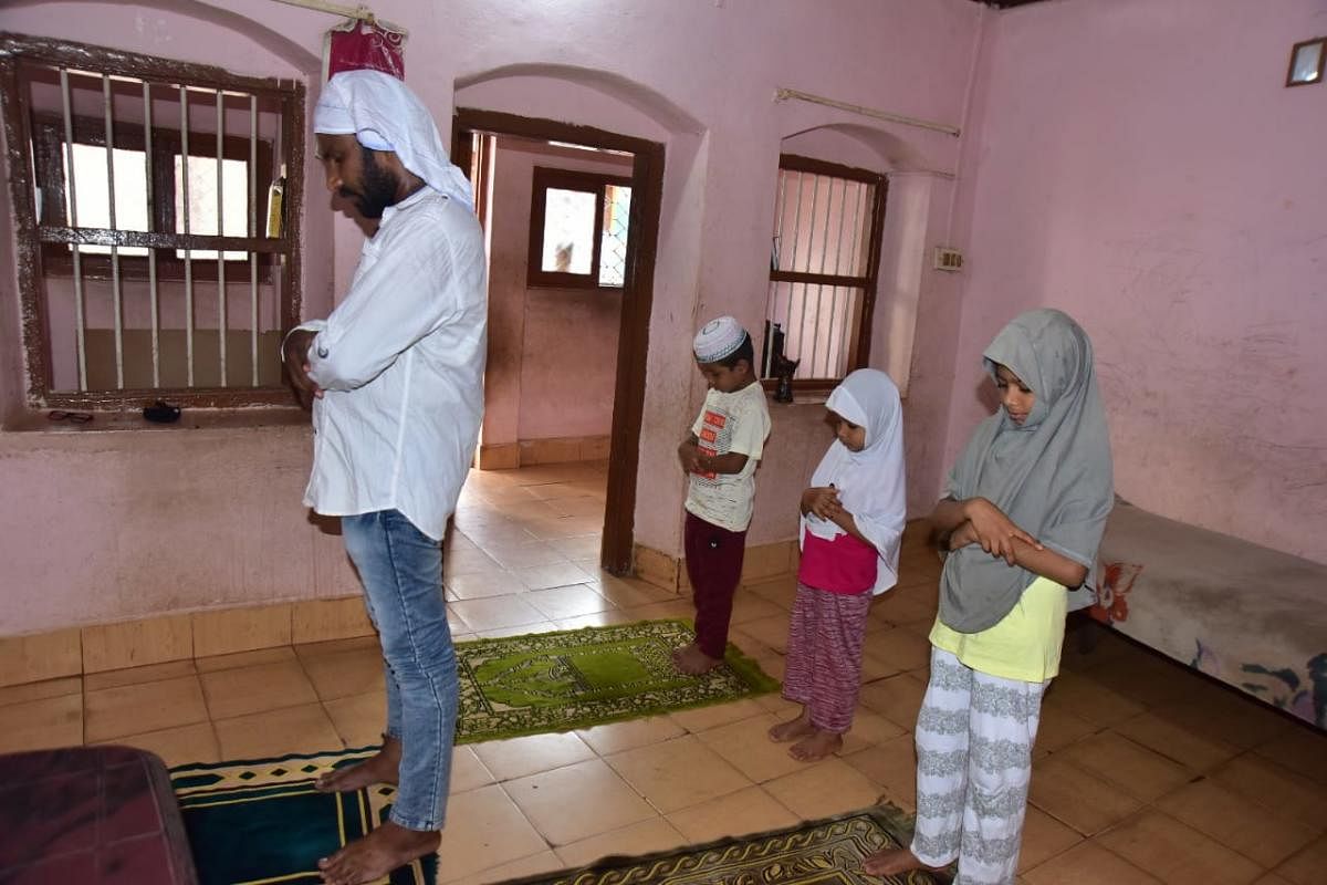 A Muslim family prays at home on account of Eid-ul-Fitr at Bunder in Mangaluru on Sunday.