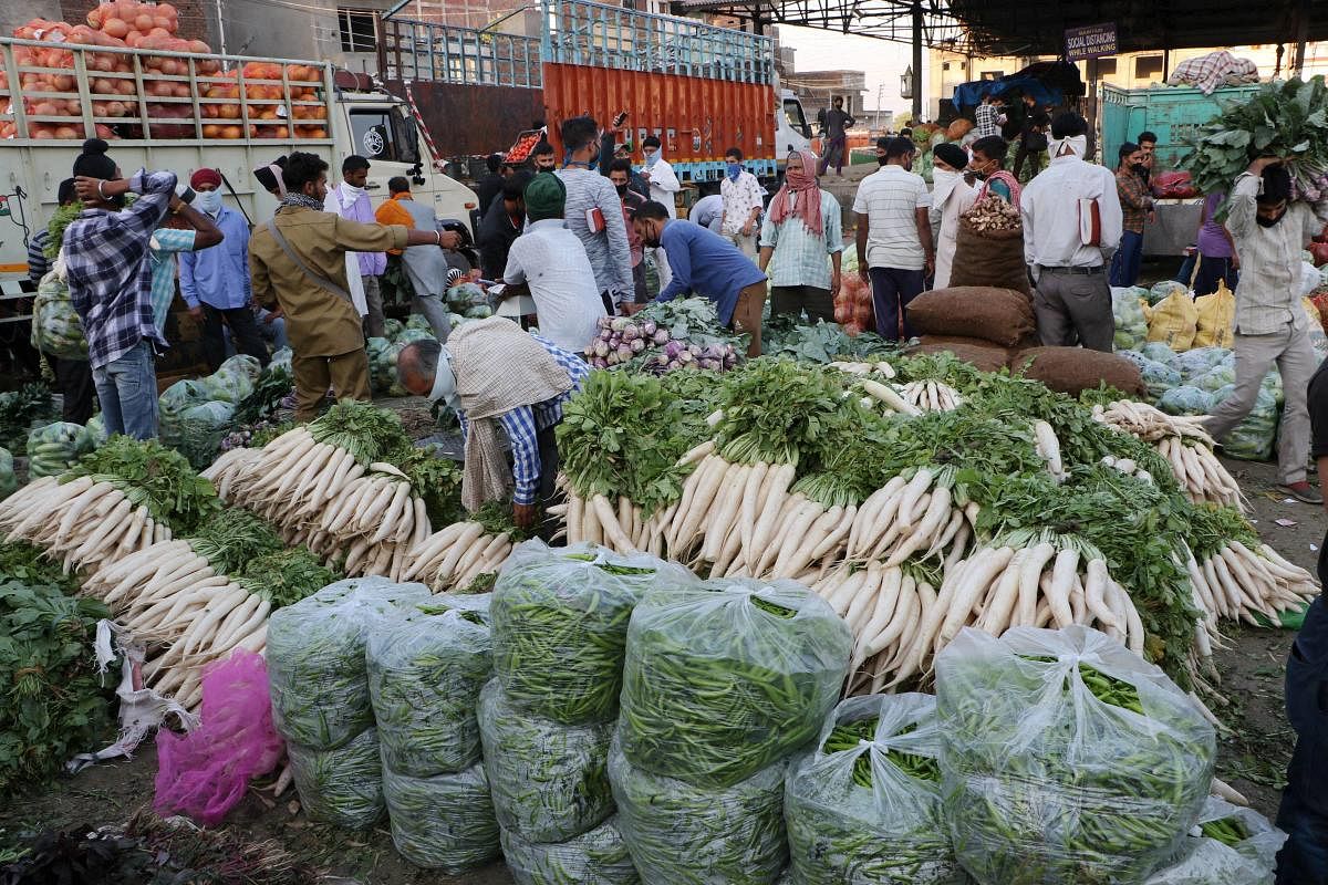 People, not adhering to social distancing norms, buy vegetables at t a wholesale market, during the ongoing COVID-19 nationwide lockdown, in Jammu, Friday, May 22, 2020. (PTI Photo)