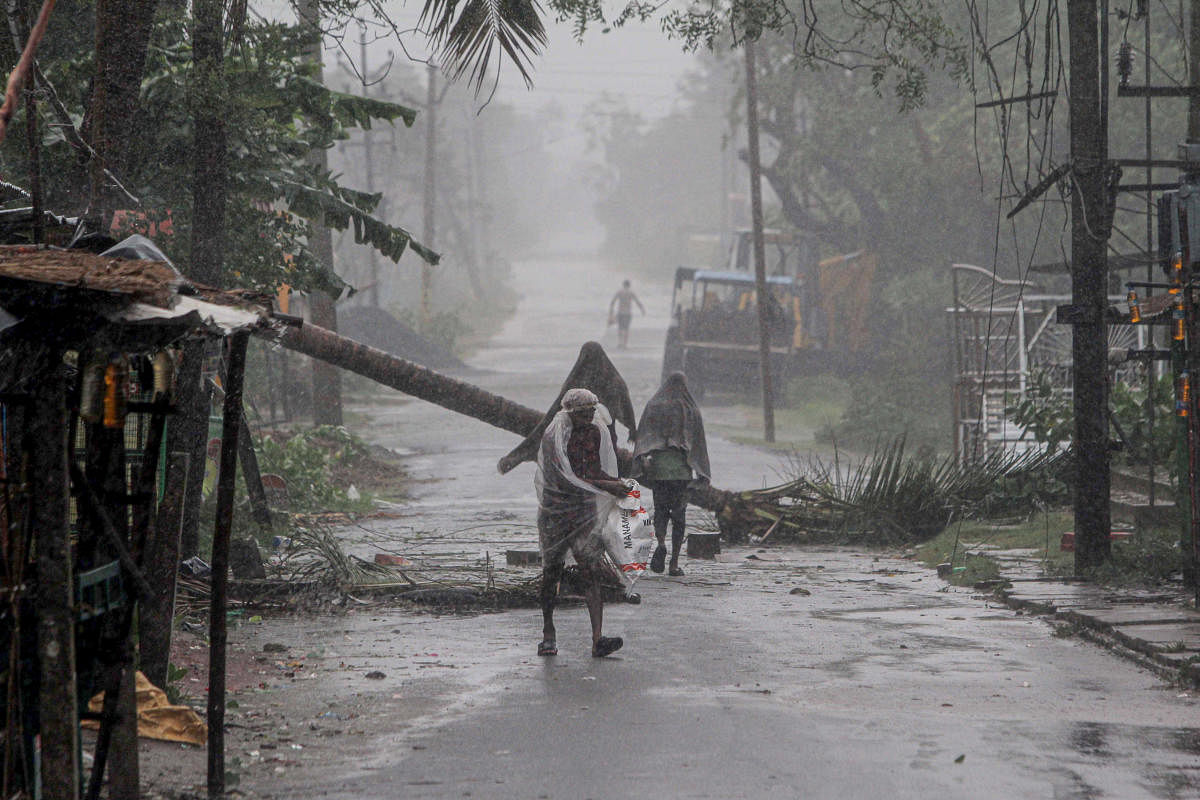 People make way through gusty winds as super cyclone Amphan makes landfall, near Dhamara Port in Bhadrak district, Wednesday, May 20, 2020. (PTI Photo) 