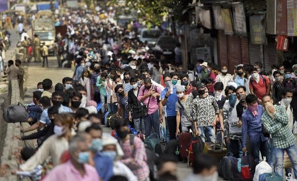 Migrants gather outside Dharavi slum to board buses for a railway station for their onward journey by special train to reach their native places, during ongoing COVID-19 lockdown, in Mumbai, Sunday, May 24, 2020. (PTI Photo/Kunal Patil)