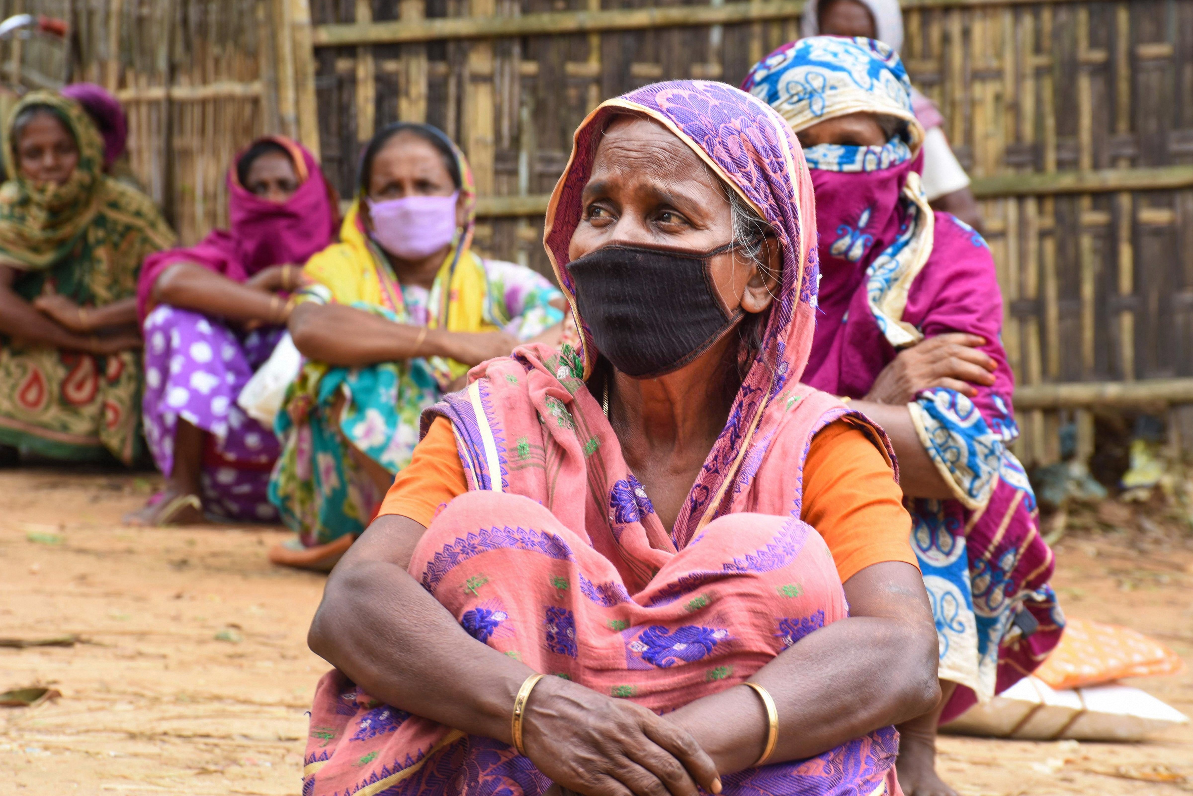 Women wait to collect free vegetables distributed by an NGO during ongoing COVID-19 lockdown near Indo-Bangladesh border, in Agartala. (PTI Photo)