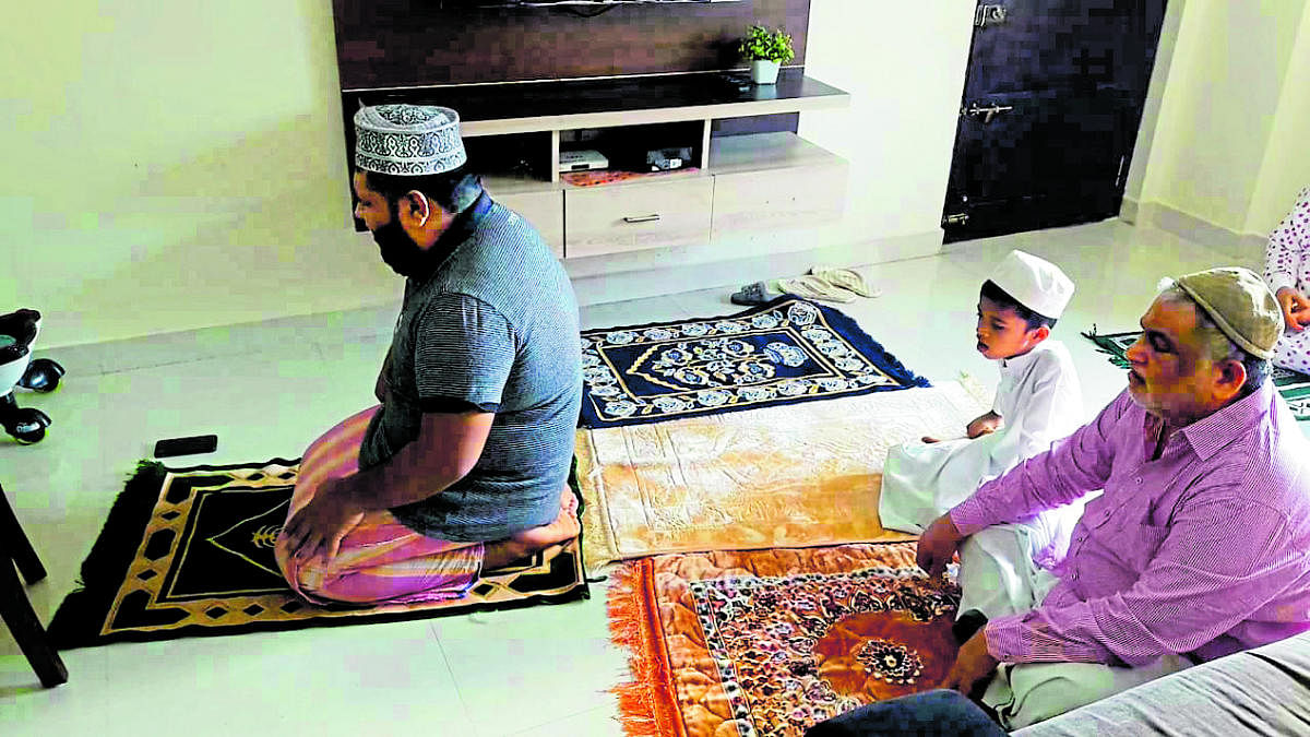 A Muslim family offers prayers in its house on the occasion of Eid-ul-Fitr, in Mangaluru on Sunday. 