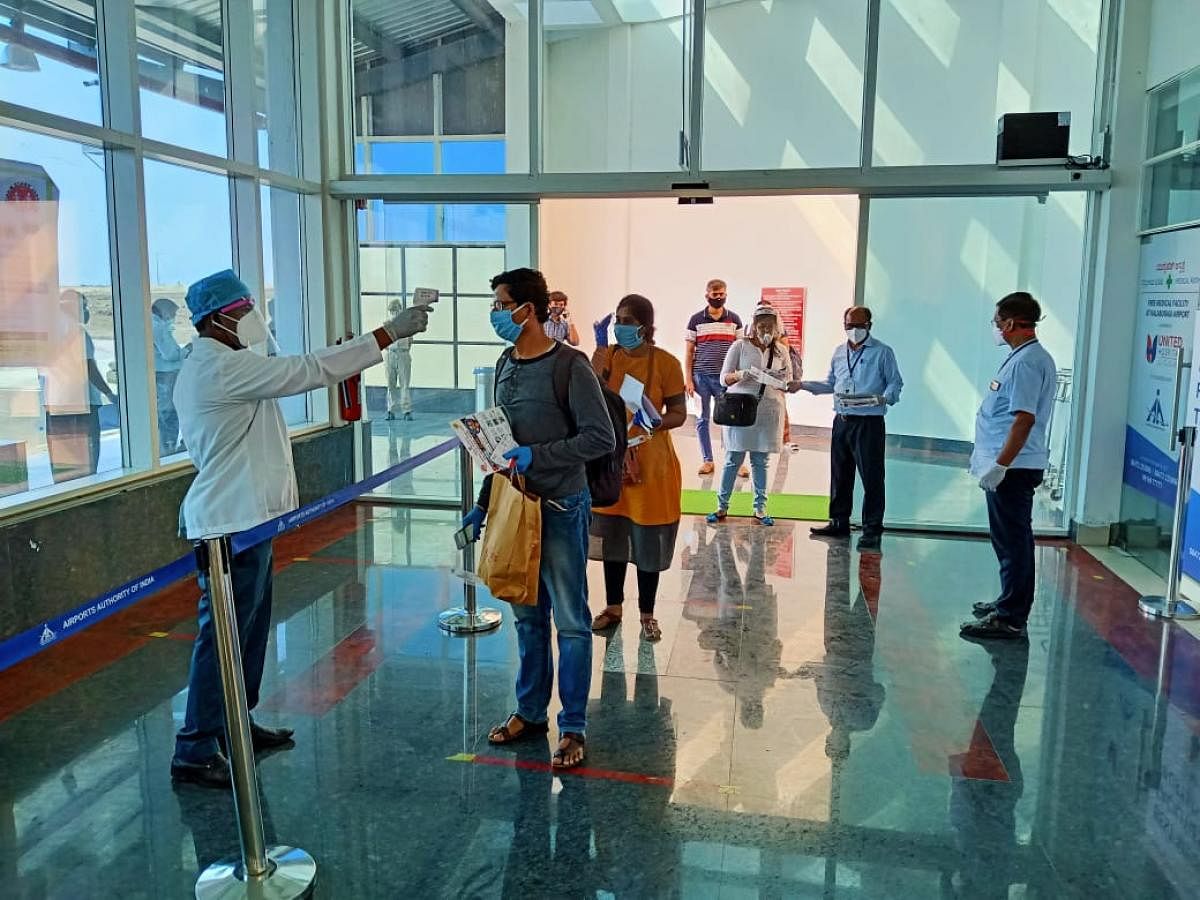 A health personnel conducts thermal screening of passengers who arrived at Kalaburagi airport from Bengaluru on Monday. DH Photo